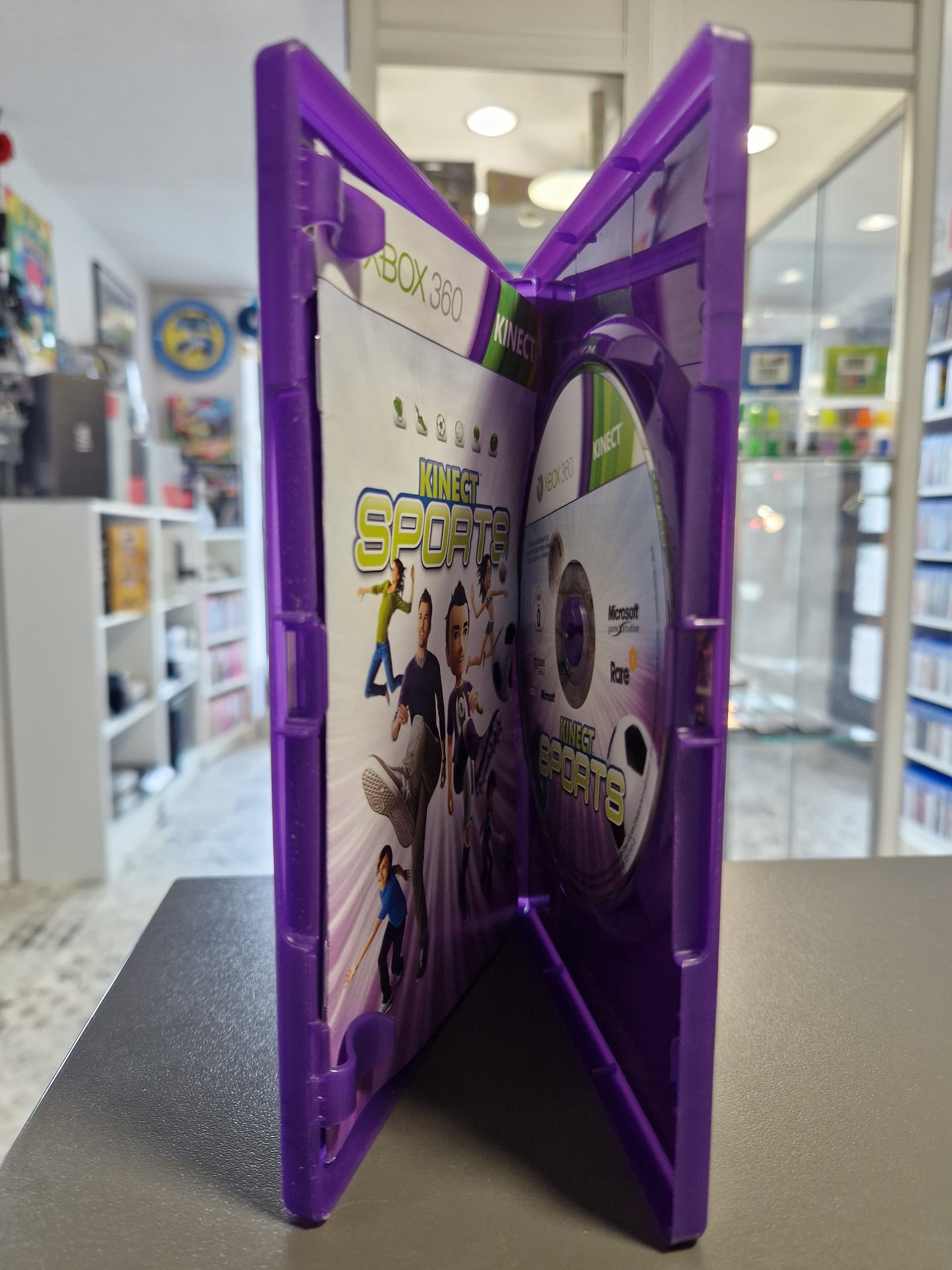 Geöffnete Xbox 360 Hülle zeigt die Spiele-Disc sicher auf der Halterung und das originale Booklet.