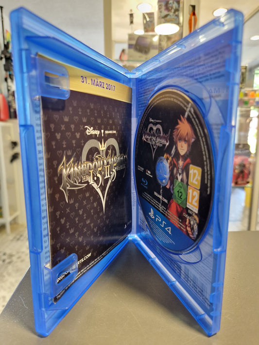 Geöffnete PS4 Hülle von Kingdom Hearts HD 2.8 mit Spiele-Disc und Square Enix Beilage