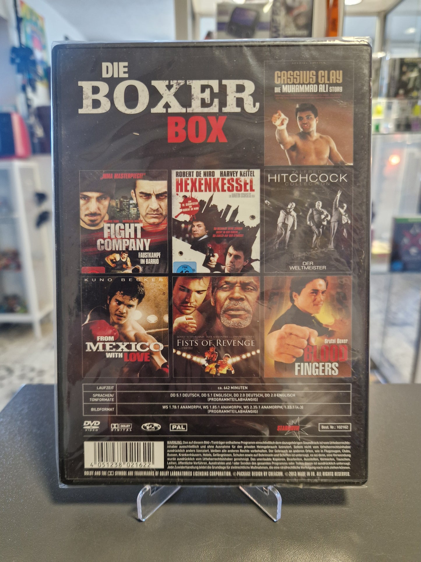 Rückseite der Filmsammlung Die Boxer Box auf DVD. Zu sehen sind die Cover der 7 enthaltenen Filme wie Hexenkessel und Blood Fingers sowie die technischen Daten mit ca. 642 Minuten Laufzeit und der EAN-Barcode.
