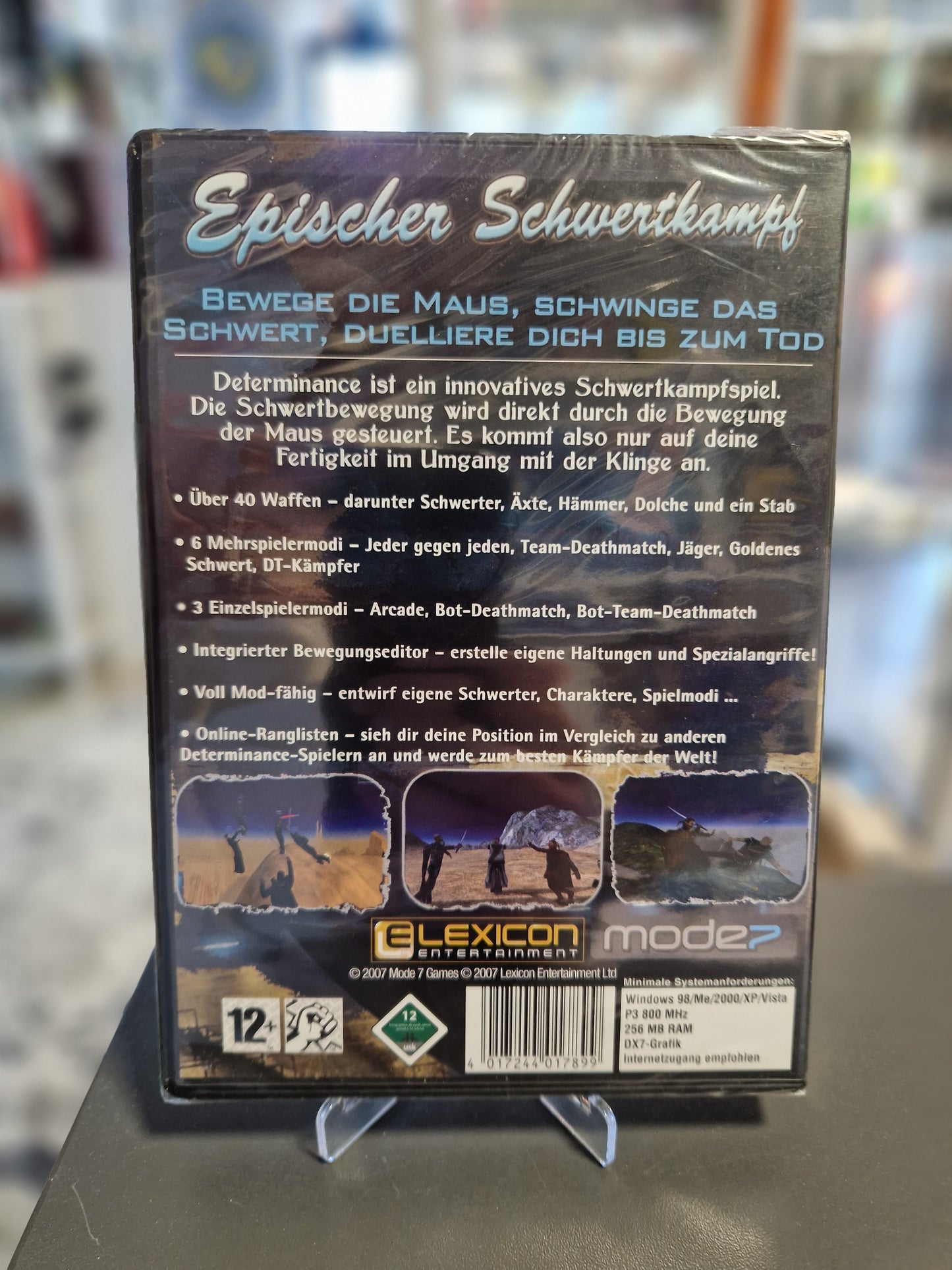 Rückseite der Determinance Spielehülle mit dem Titel Epischer Schwertkampf. Beschreibung der Maussteuerung, der 40 Waffen und Spielmodi auf Deutsch. Inklusive Systemanforderungen für Windows 98 bis Vista.