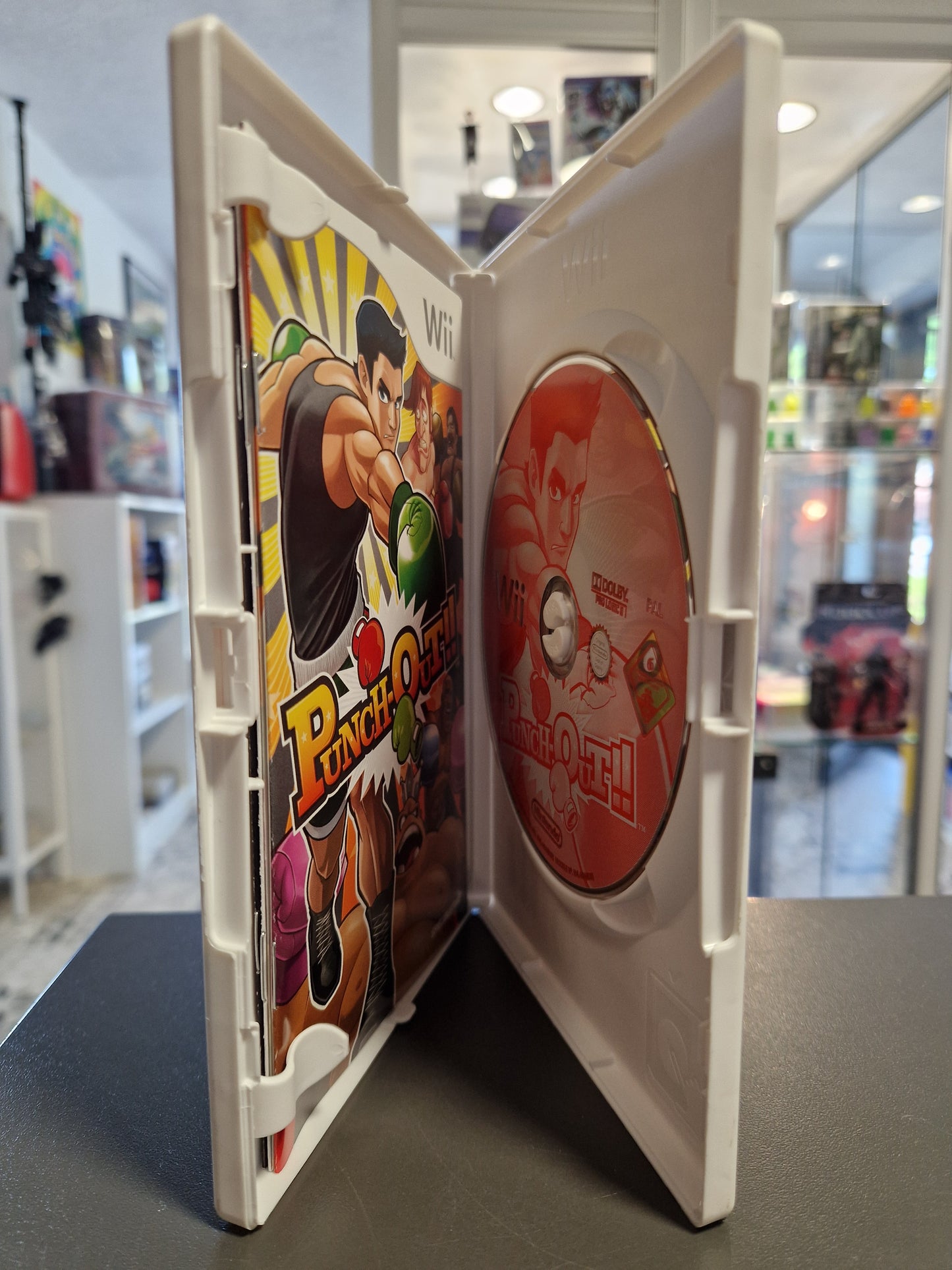 Geöffnete Nintendo Wii Hülle von Punch-Out!! mit roter Spiele-Disc und gedruckter Anleitung