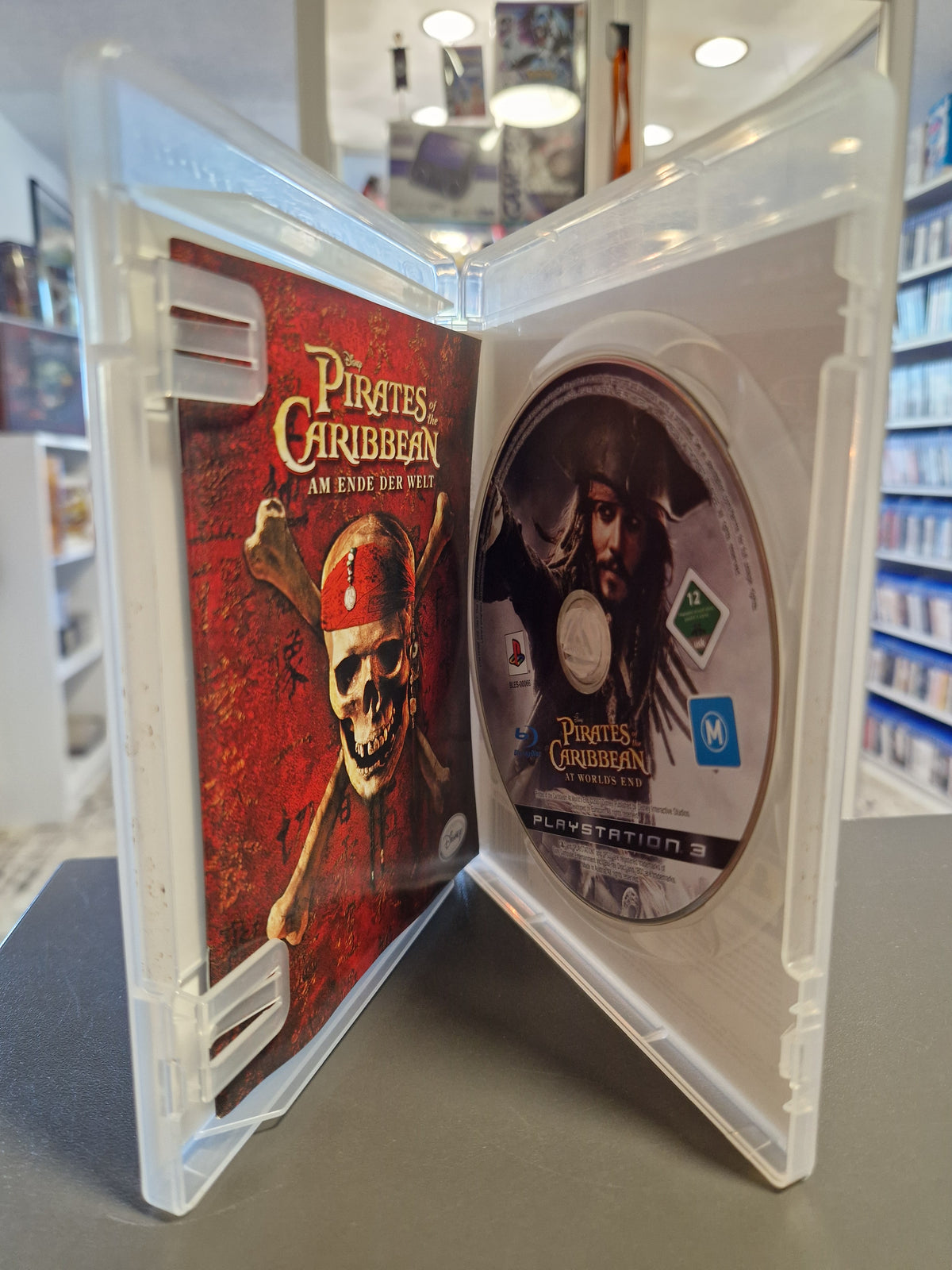 Geöffnete PlayStation 3 Hülle von Pirates of the Caribbean mit Blu-ray Disc und Spielanleitung.