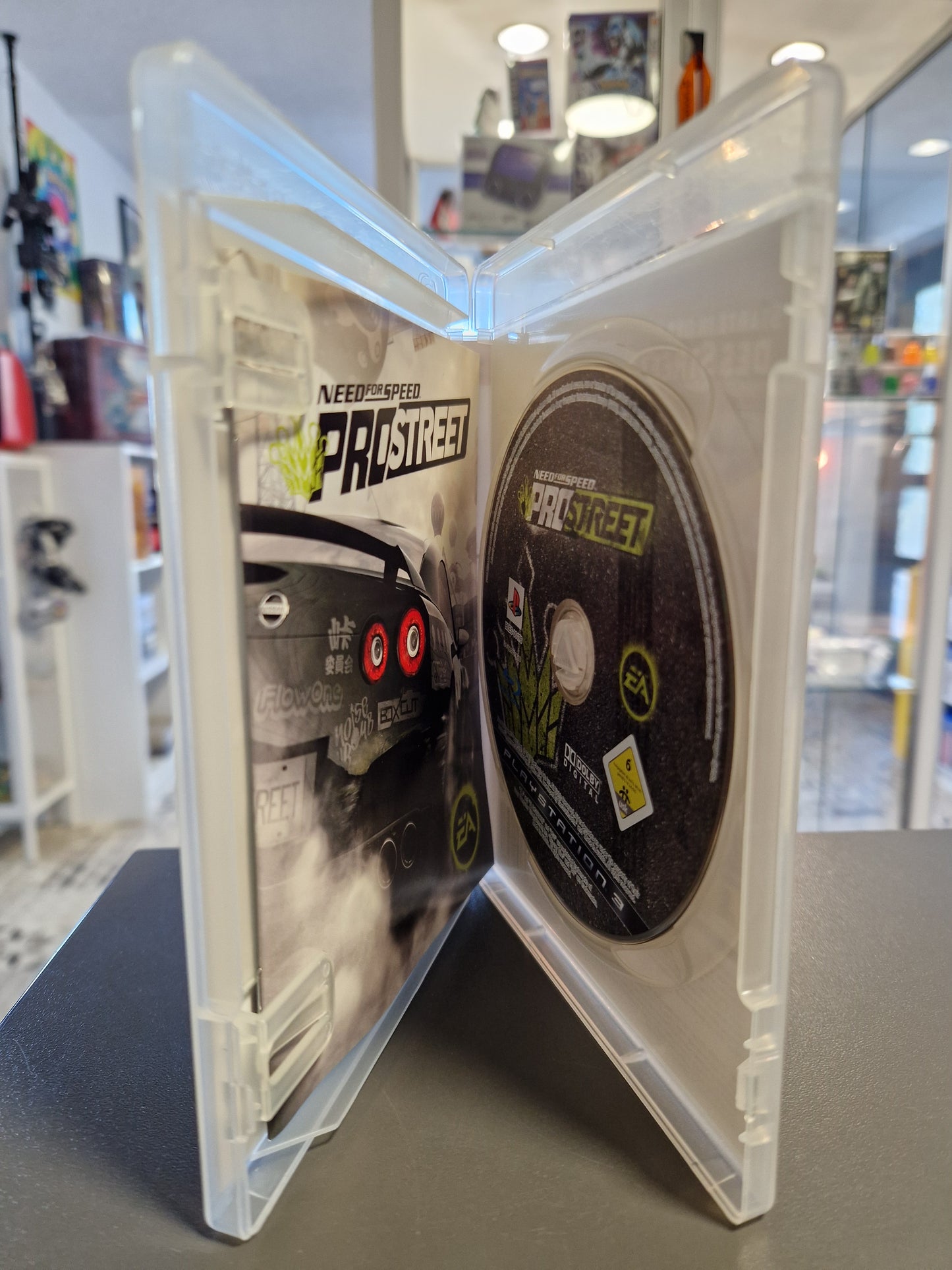 Geöffnete PS3 Hülle mit der kratzerfreien Blu-ray Disc und der originalen Spieleanleitung.