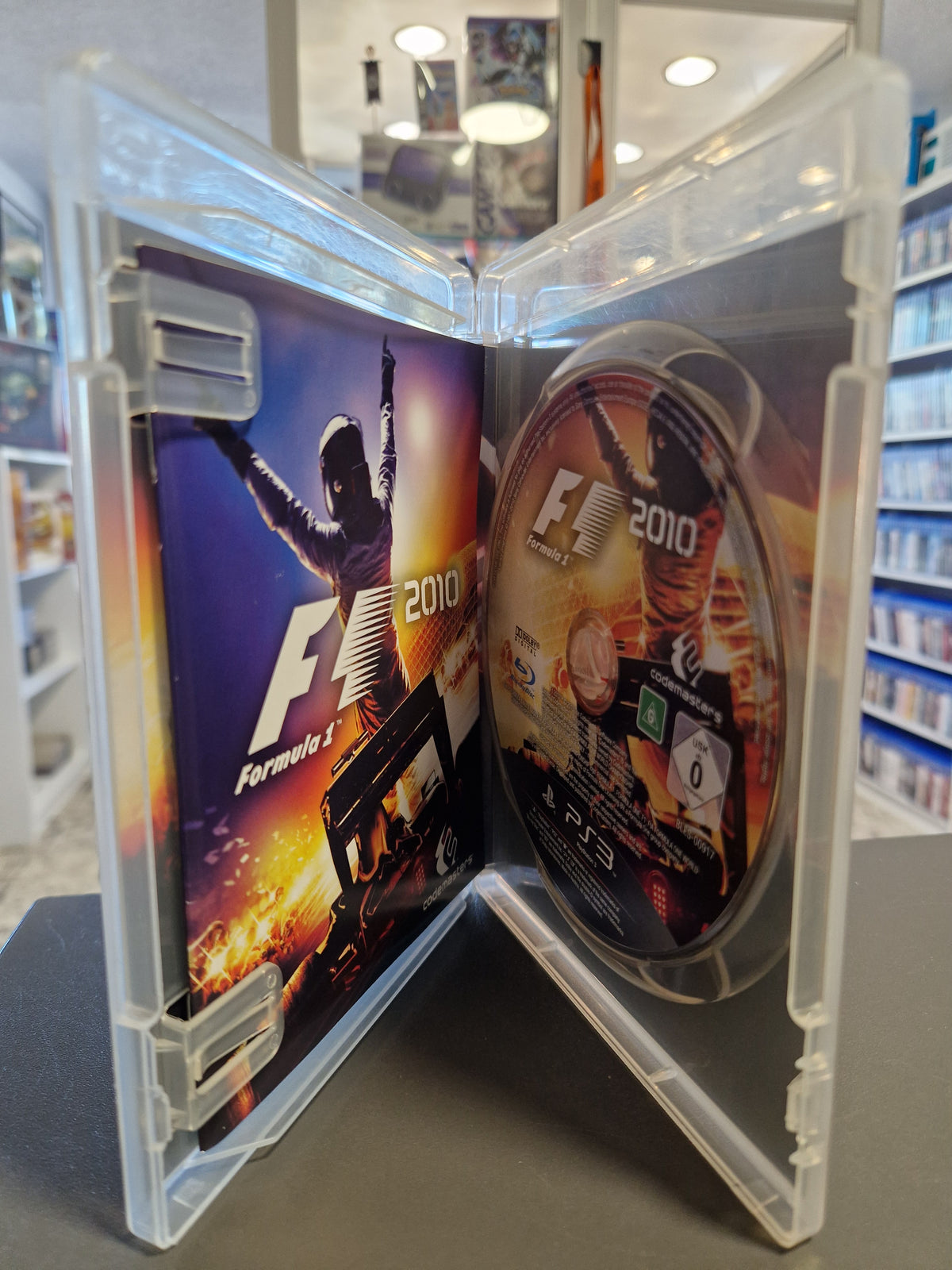 Geöffnete PlayStation 3 Hülle von F1 2010 mit kratzerfreier Disc und Spielanleitung.