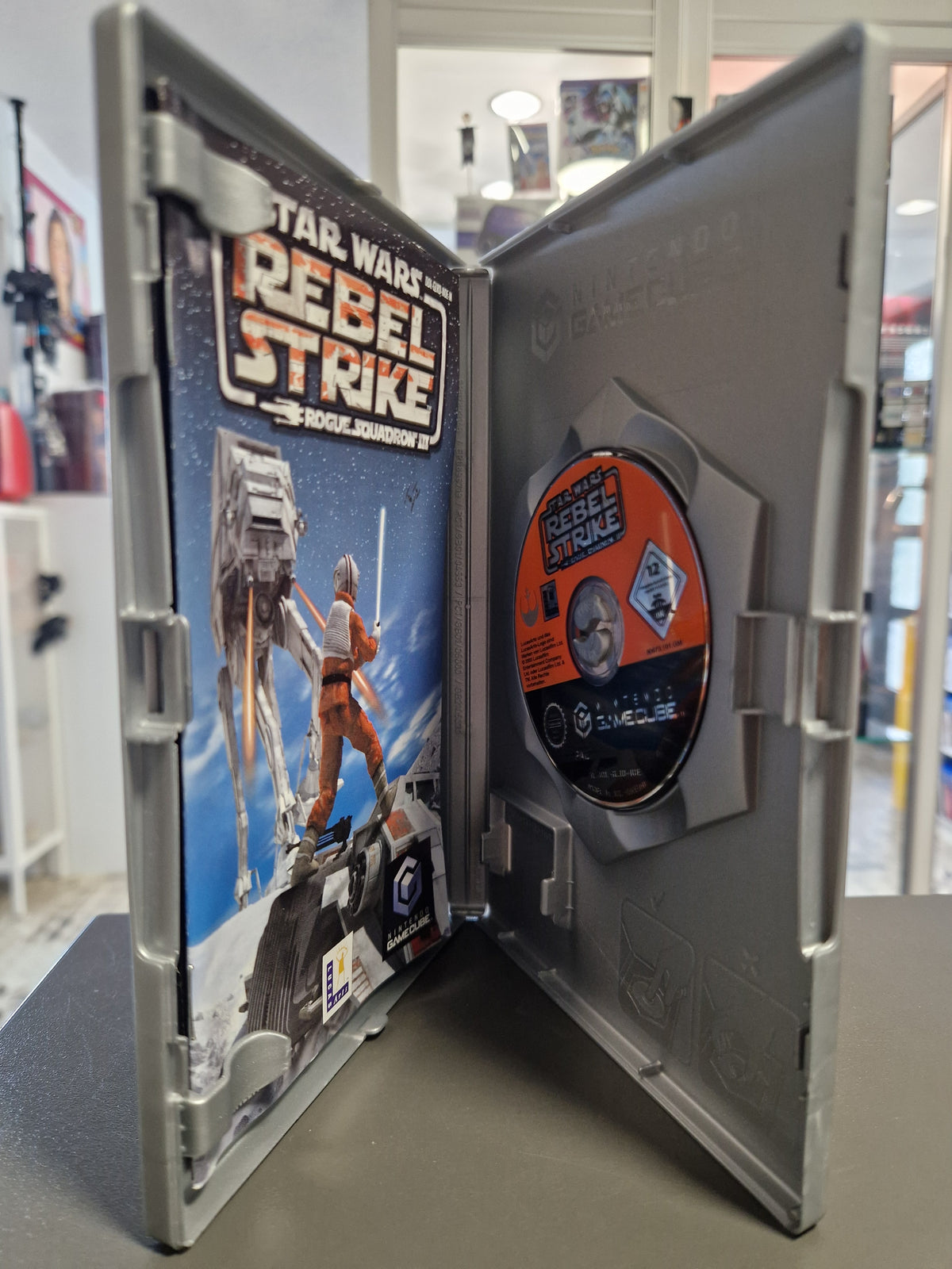 Geöffnete GameCube Hülle von Star Wars Rebel Strike mit Disc und Spielanleitung.