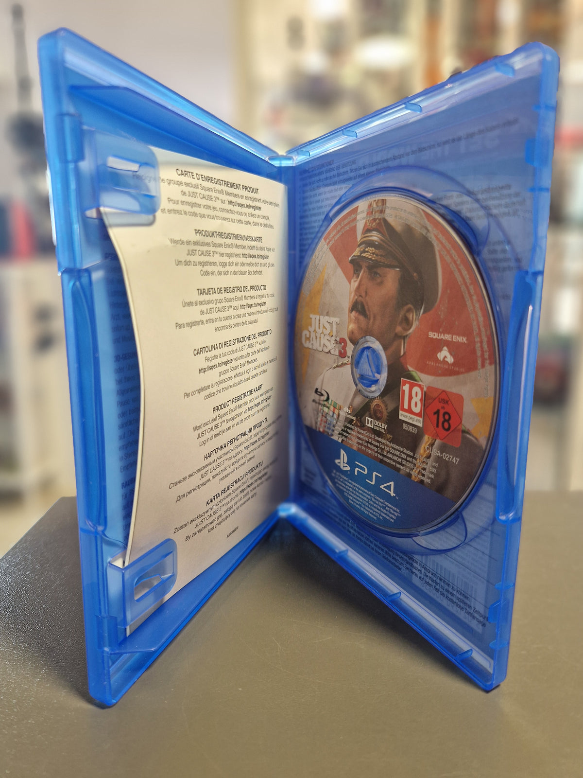 Geöffnete Blu-ray Hülle von Just Cause 3 für PS4 mit Disc und Registrierungskarte.