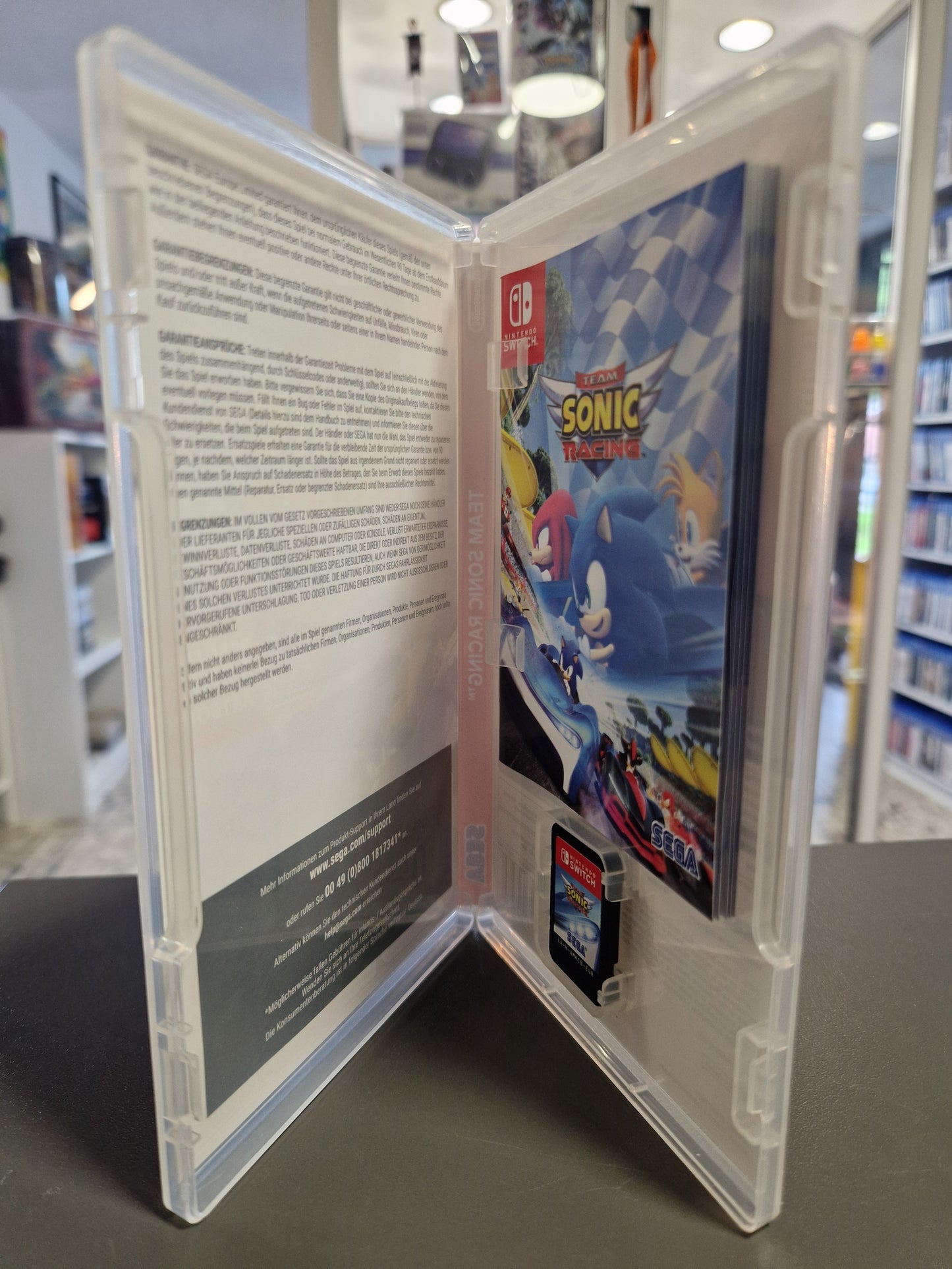 Geöffnete Spielehülle von Team Sonic Racing für Nintendo Switch mit eingelegter Cartridge und dem exklusiven Sonic-Artbook.