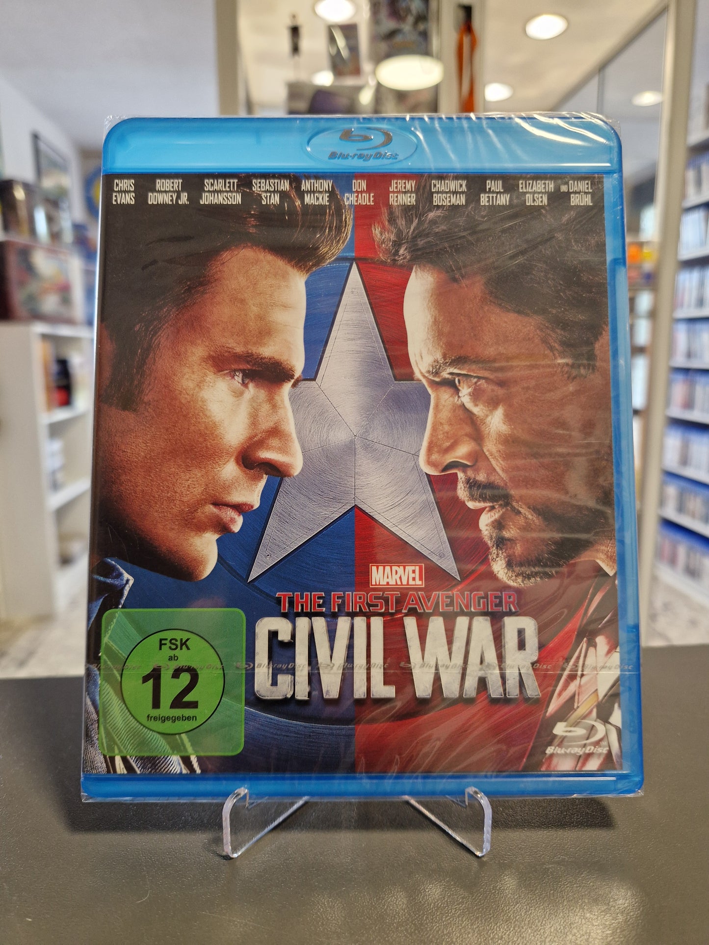 Blu-ray Cover von Marvels „The First Avenger: Civil War“ mit FSK 12 Logo. Zu sehen sind Captain America und Iron Man im Profil, die sich gegenüberstehen.
