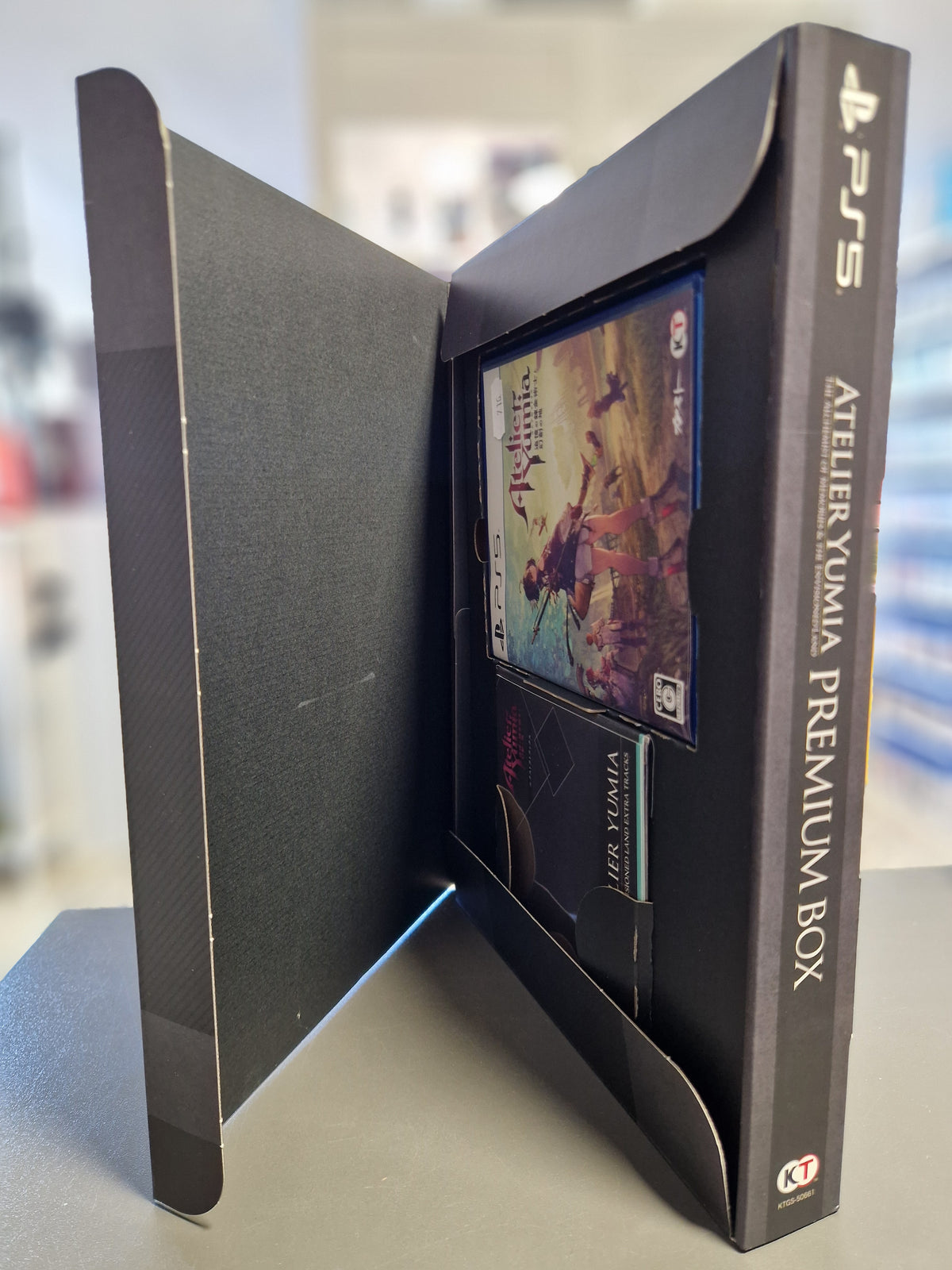Geöffnete Atelier Yumia Premium Box mit PS5 Spielhülle und Soundtrack CD.