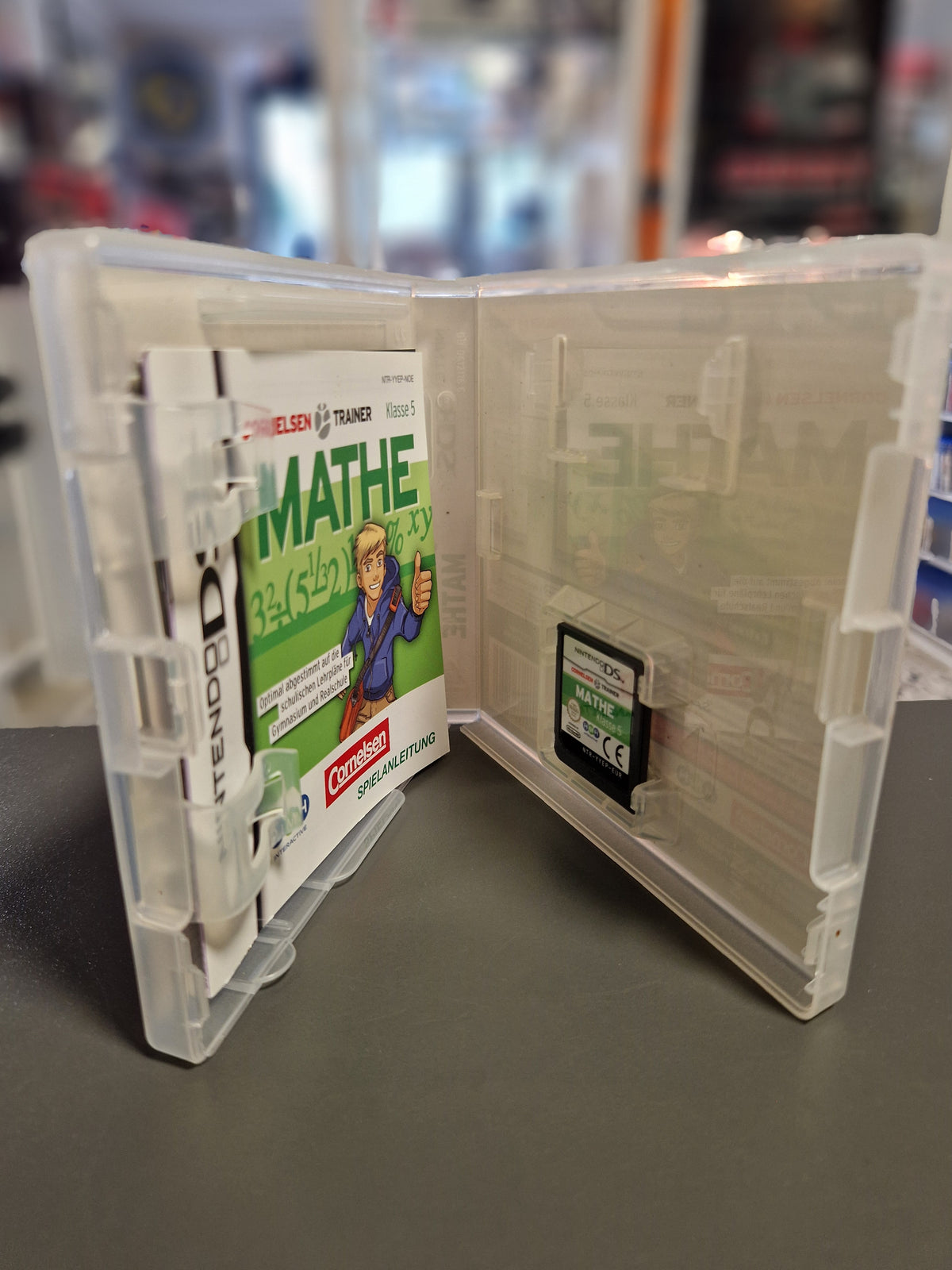 Geöffnete Nintendo DS Hülle von Cornelsen Trainer Mathe Klasse 5 mit Modul und Anleitung.