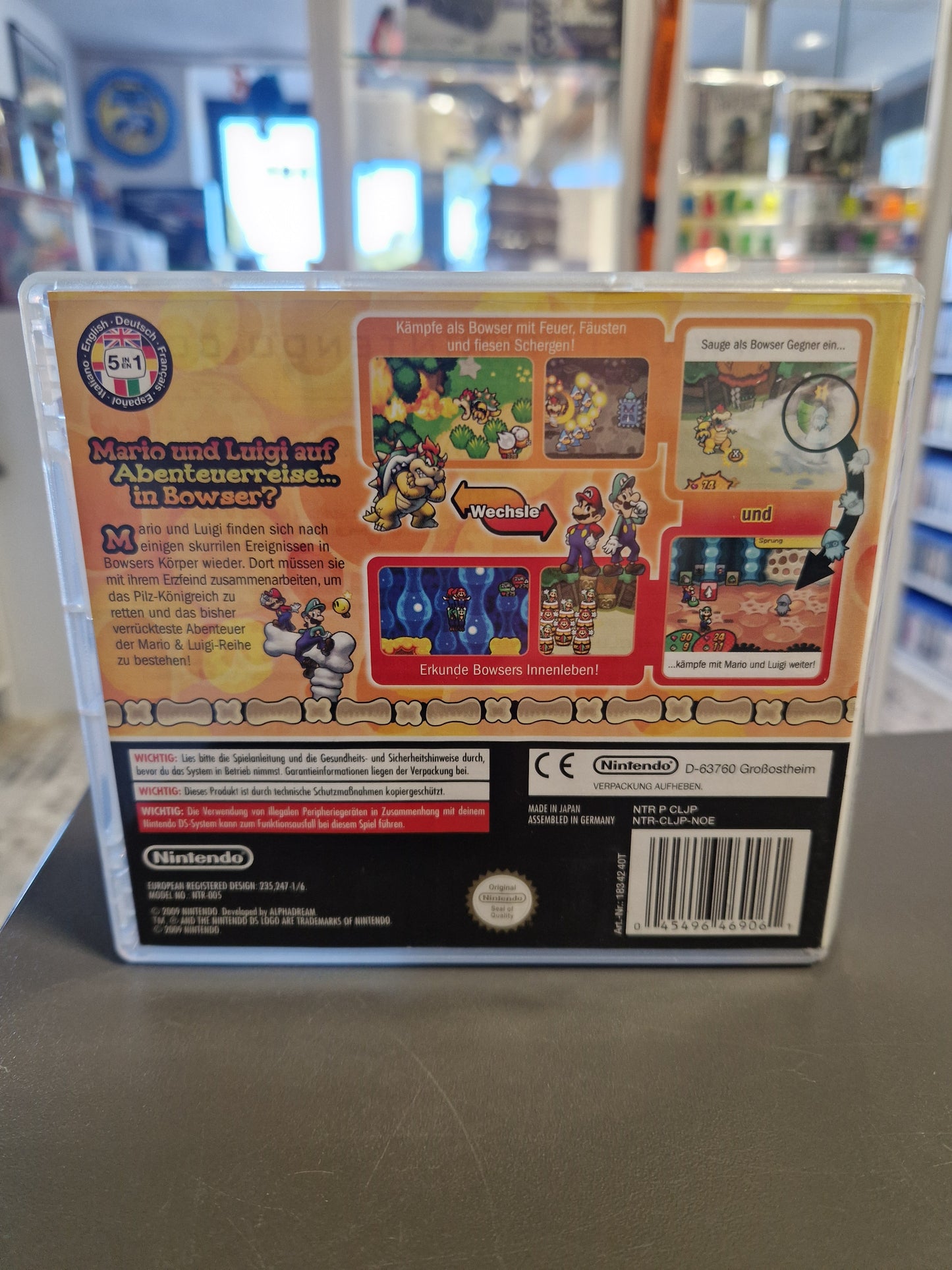 Rückseite der Verpackung mit Spielszenen, die das Gameplay im Inneren Bowsers zeigen.