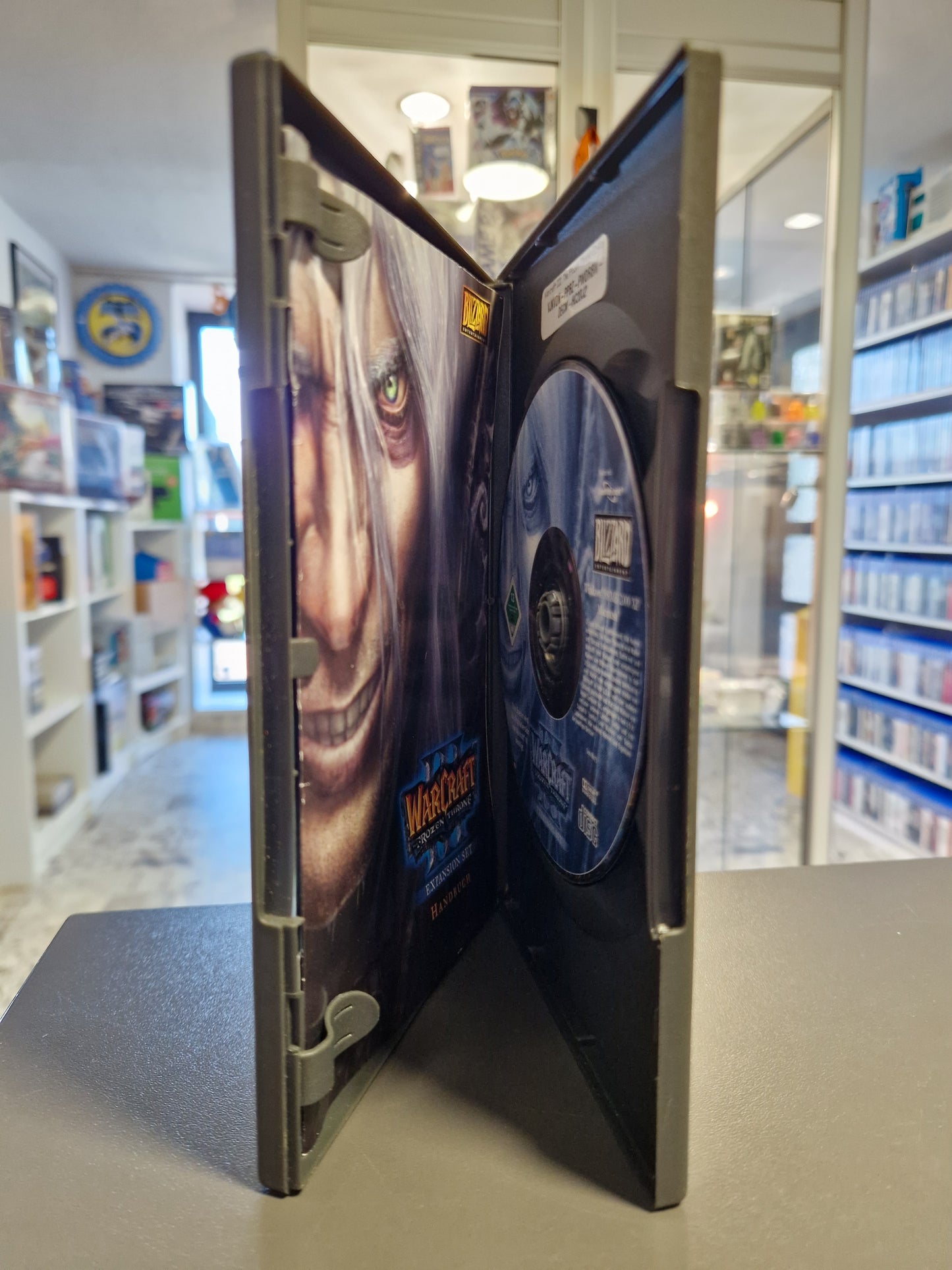 Geöffnete Box mit der Frozen Throne CD, dem Handbuch und dem Blizzard Produktkatalog.