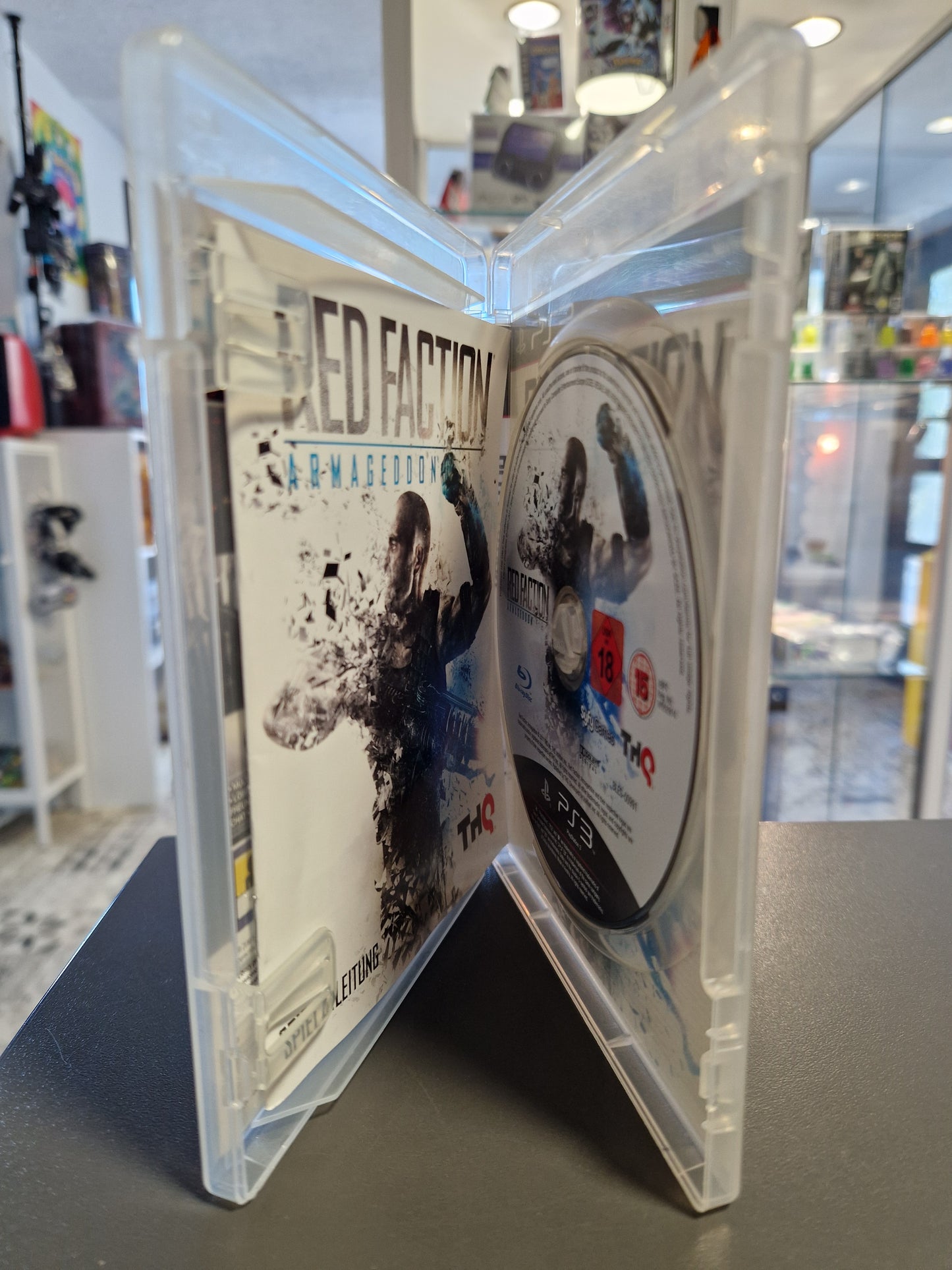 Geöffnete PS3 Hülle mit der kratzerfreien Blu-ray Disc und der originalen Spieleanleitung.