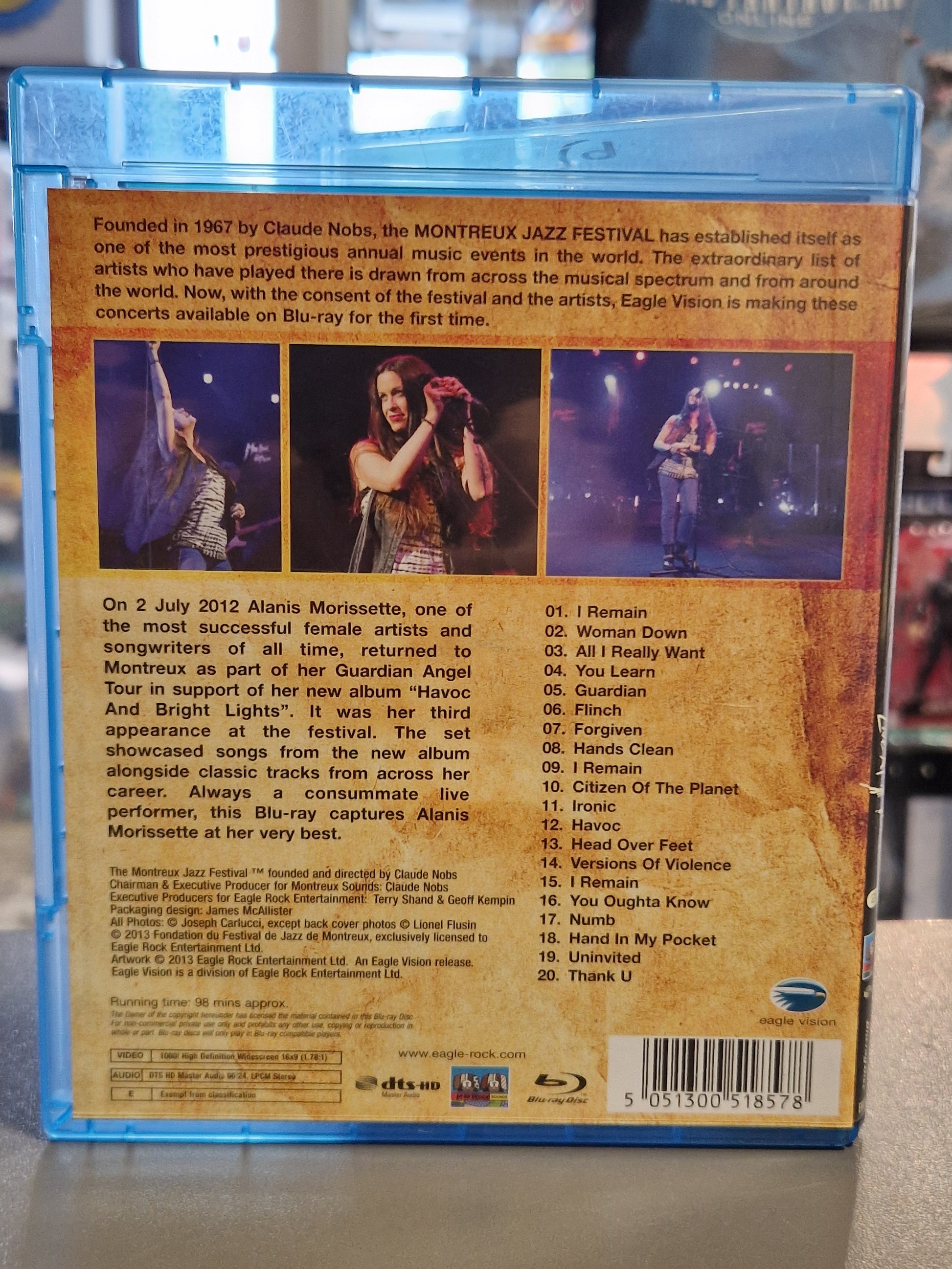 Rückseite der Alanis Morissette Live at Montreux 2012 Blu-ray Hülle mit drei Live-Fotos, der kompletten Trackliste von 20 Songs, Audio-Spezifikationen von Eagle Vision und dem Barcode EAN 5051300518578.