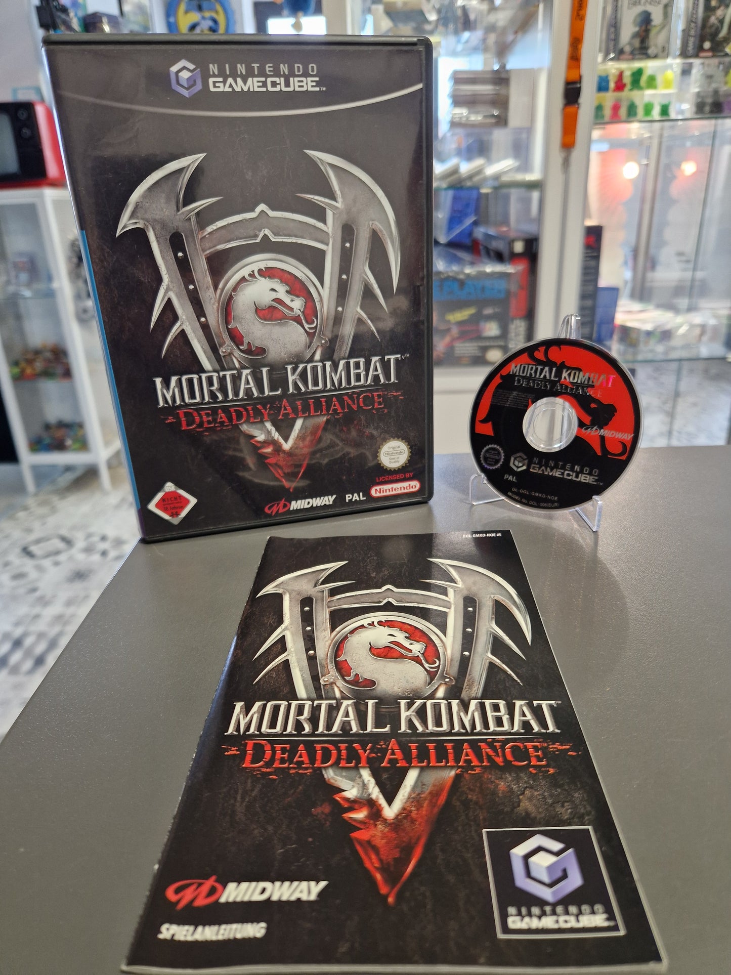 Nintendo GameCube Mortal Kombat: Deadly Alliance in der deutschen Erstausgabe. Inklusive Anleitung und Hülle. Disc in nahezu neuwertigem Zustand mit minimalsten Gebrauchsspuren. Geprüft von Memory Lane.