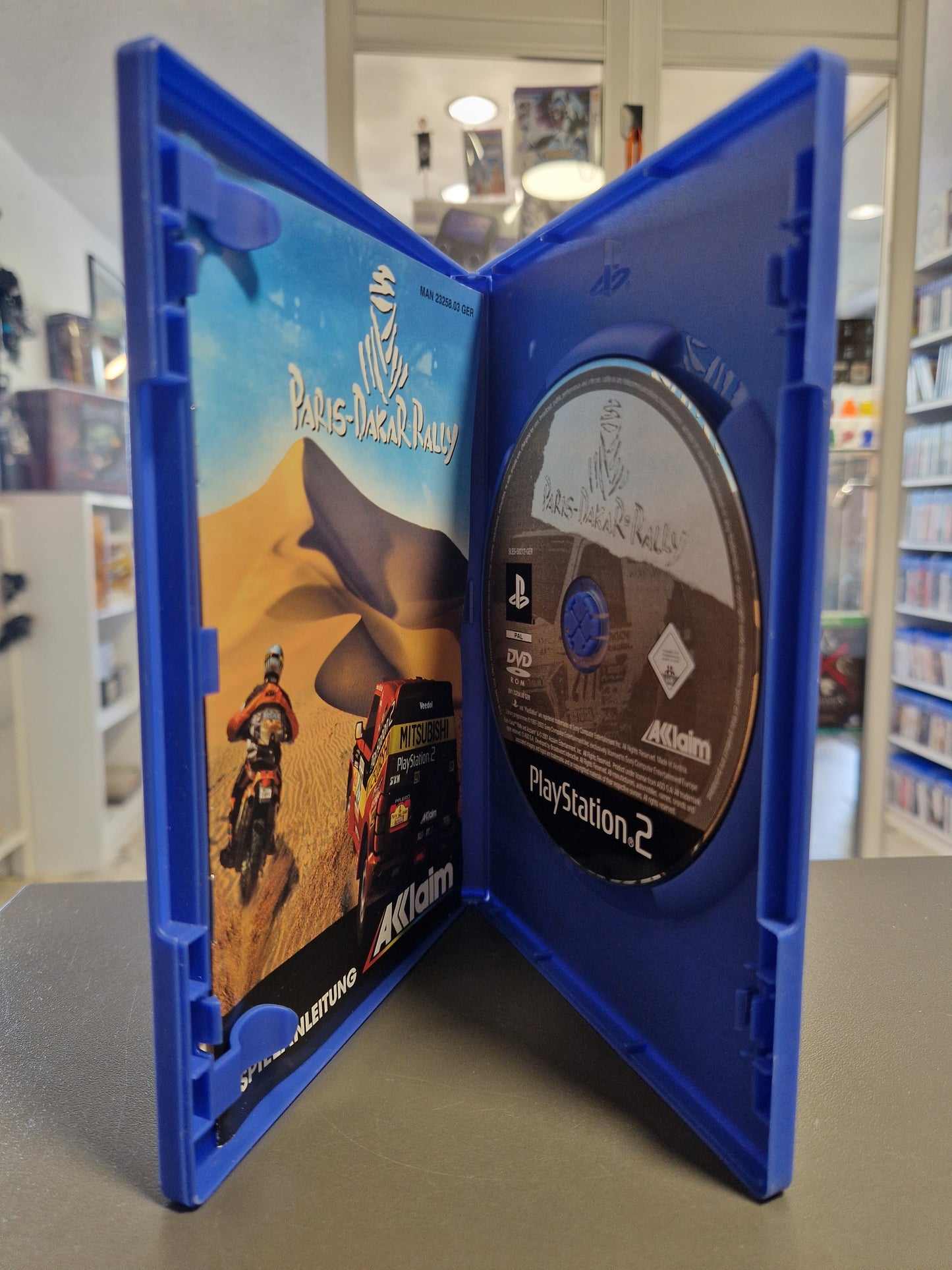 Geöffnete PlayStation 2 Hülle von Paris-Dakar Rally mit Disc und Spielanleitung.