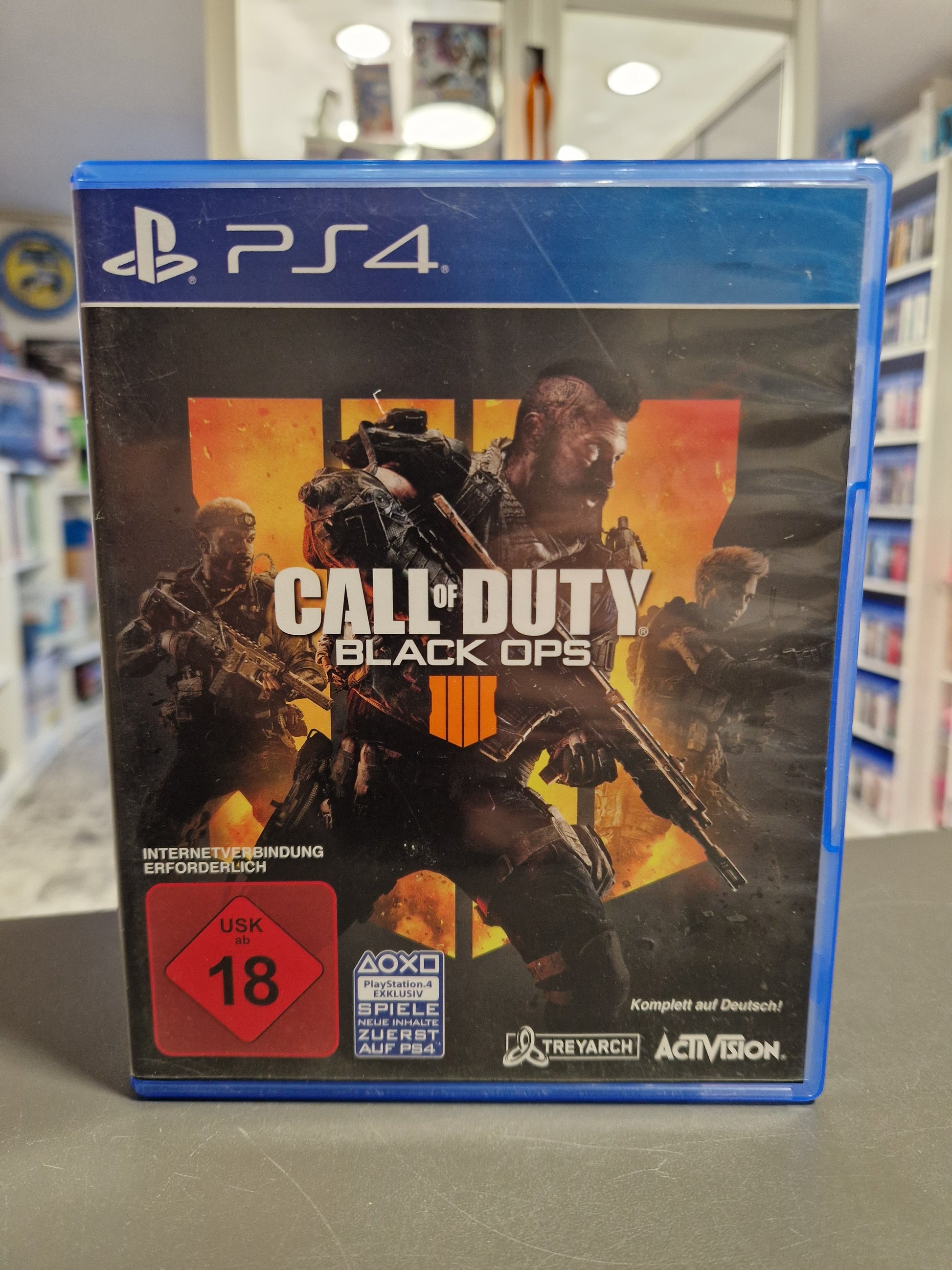 Vorderseite der PS4-Hülle von Call of Duty: Black Ops 4. Das Cover zeigt drei Soldaten vor einem orangefarbenen Hintergrund. Rotes USK 18 Logo und der Hinweis Komplett auf Deutsch sind sichtbar.