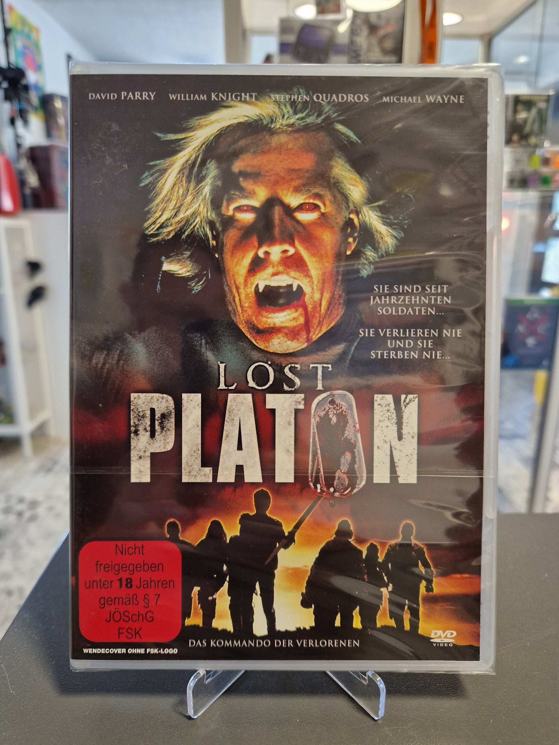Neu und originalverpackte DVD des Horror-Actionfilms Lost Platon mit FSK 18 Freigabe. Das Cover zeigt das blutverschmierte Gesicht eines Vampirs mit Fangzähnen sowie Soldaten als Silhouetten vor einem brennenden Himmel.