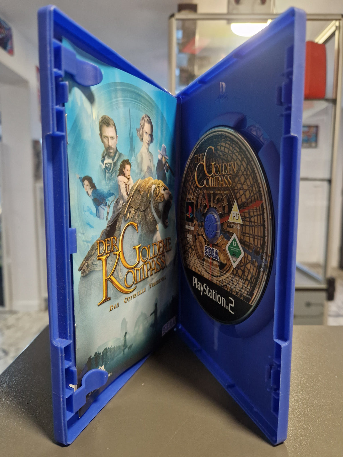 Geöffnete PS2 Hülle von Der Goldene Kompass mit DVD-ROM und Anleitungsheft