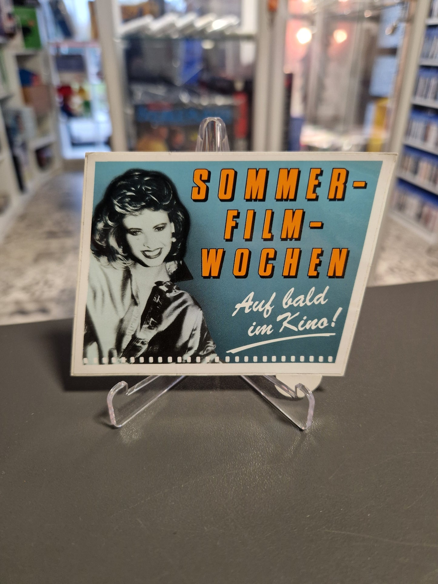 Vintage Werbesticker mit der Aufschrift "Sommer-Filmwochen - Auf bald im Kino" und Porträt einer Frau im Retro-Stil.