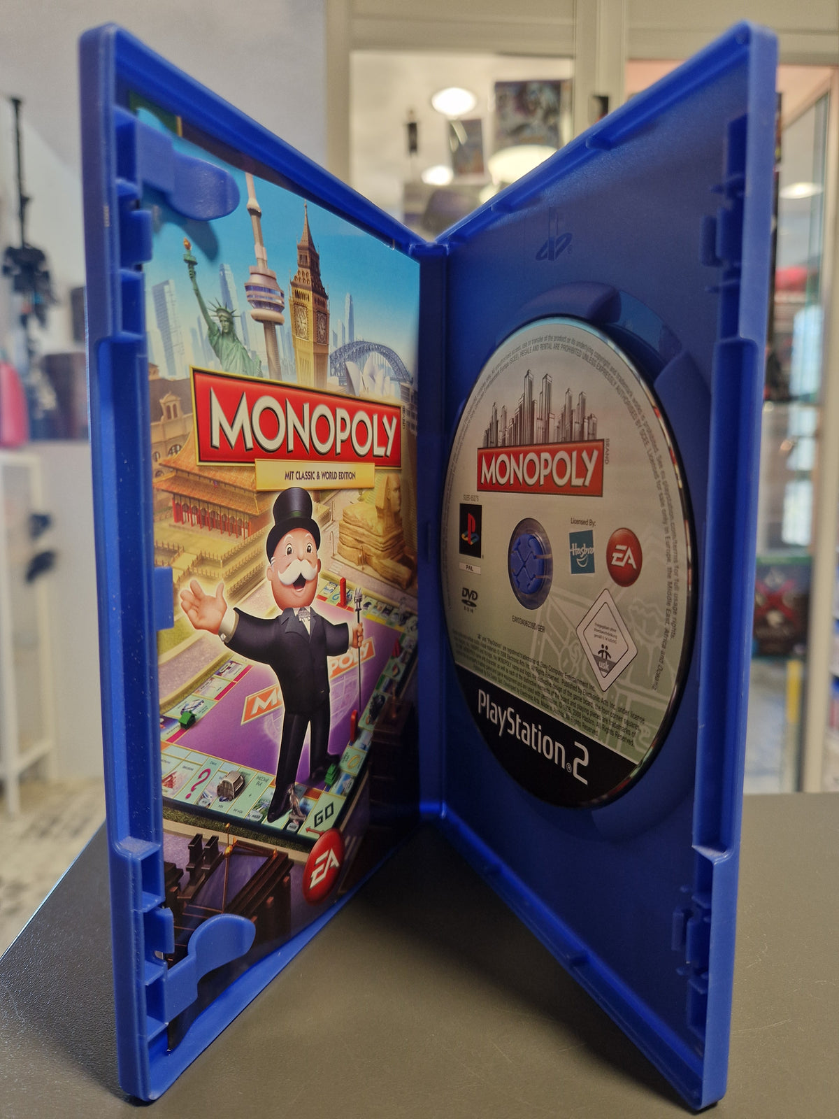 Geöffnete PS2 Hülle von Monopoly mit DVD und Anleitungsheft.