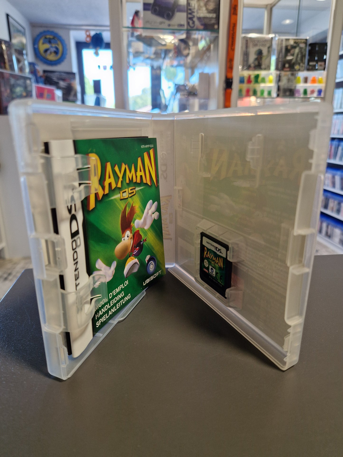 Geöffnete Nintendo DS Hülle von Rayman DS mit Blick auf das Spielmodul und die gedruckte Spielanleitung.