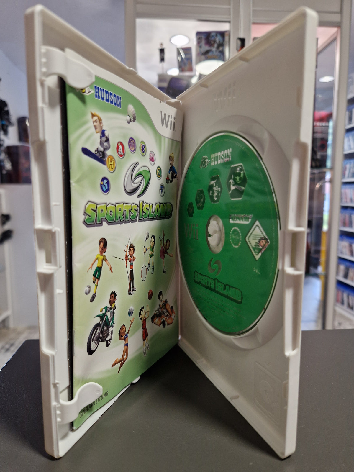 Geöffnete Nintendo Wii Hülle von Sports Island mit Disc und gedruckter Spielanleitung.