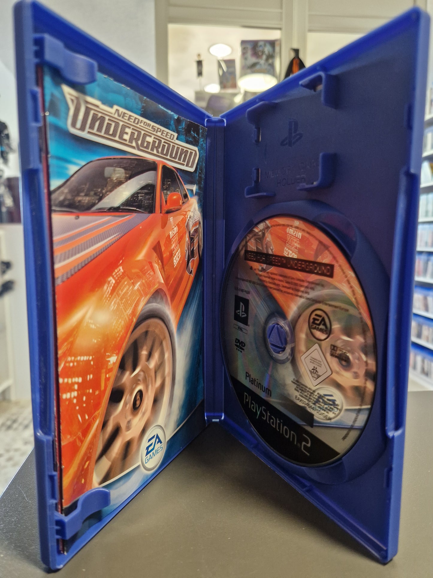 Geöffnete PS2 Hülle von Need for Speed Underground mit der Platinum Spiele-Disc.