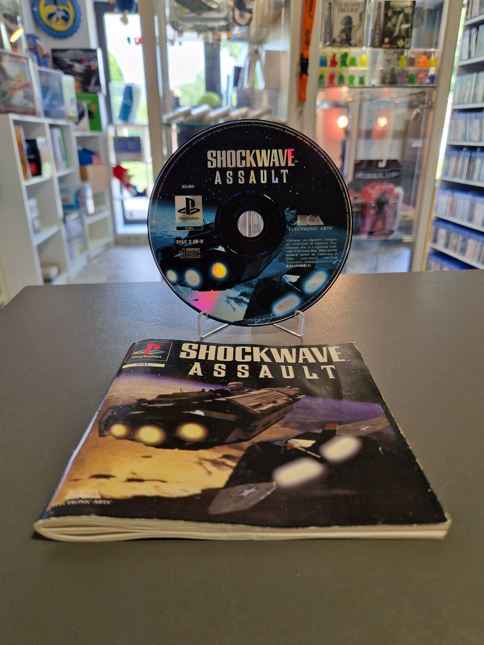 Shockwave Assault PlayStation 1 Spiel – Nur Disc 2 von 2 auf einem Ständer und das dazugehörige original Handbuch – Memory Lane Rhauderfehn.