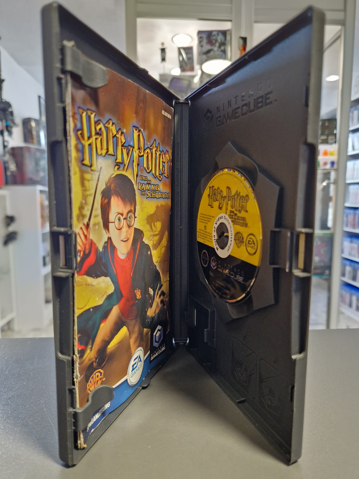 Geöffnete Nintendo GameCube Hülle von Harry Potter und die Kammer des Schreckens mit gelber Disc und Anleitung.