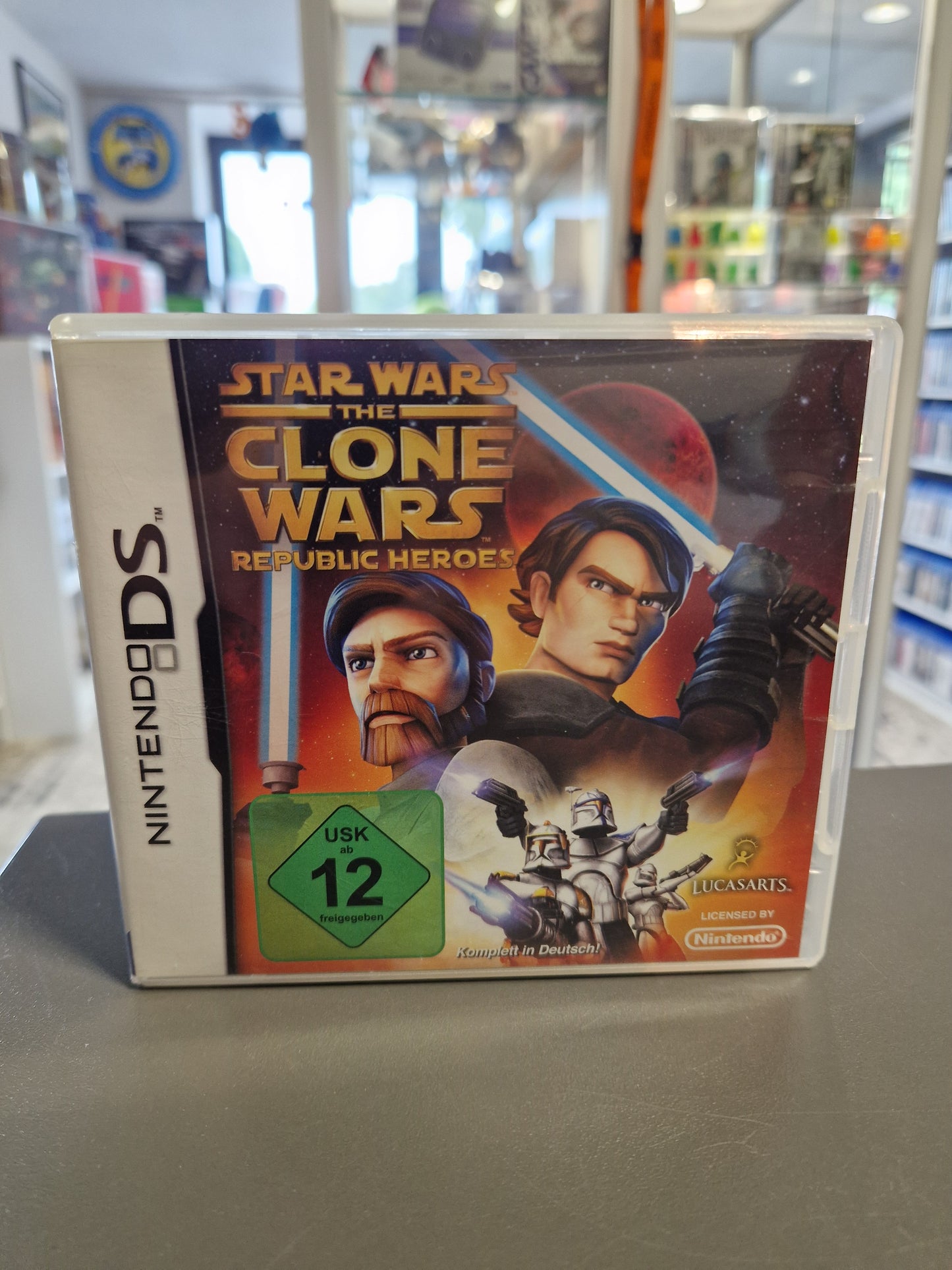 Die weiße Nintendo DS Spielehülle von Star Wars: The Clone Wars - Republic Heroes mit einer Illustration von Anakin Skywalker, Obi-Wan Kenobi und Klonkriegern sowie dem grünen USK 12 Logo.