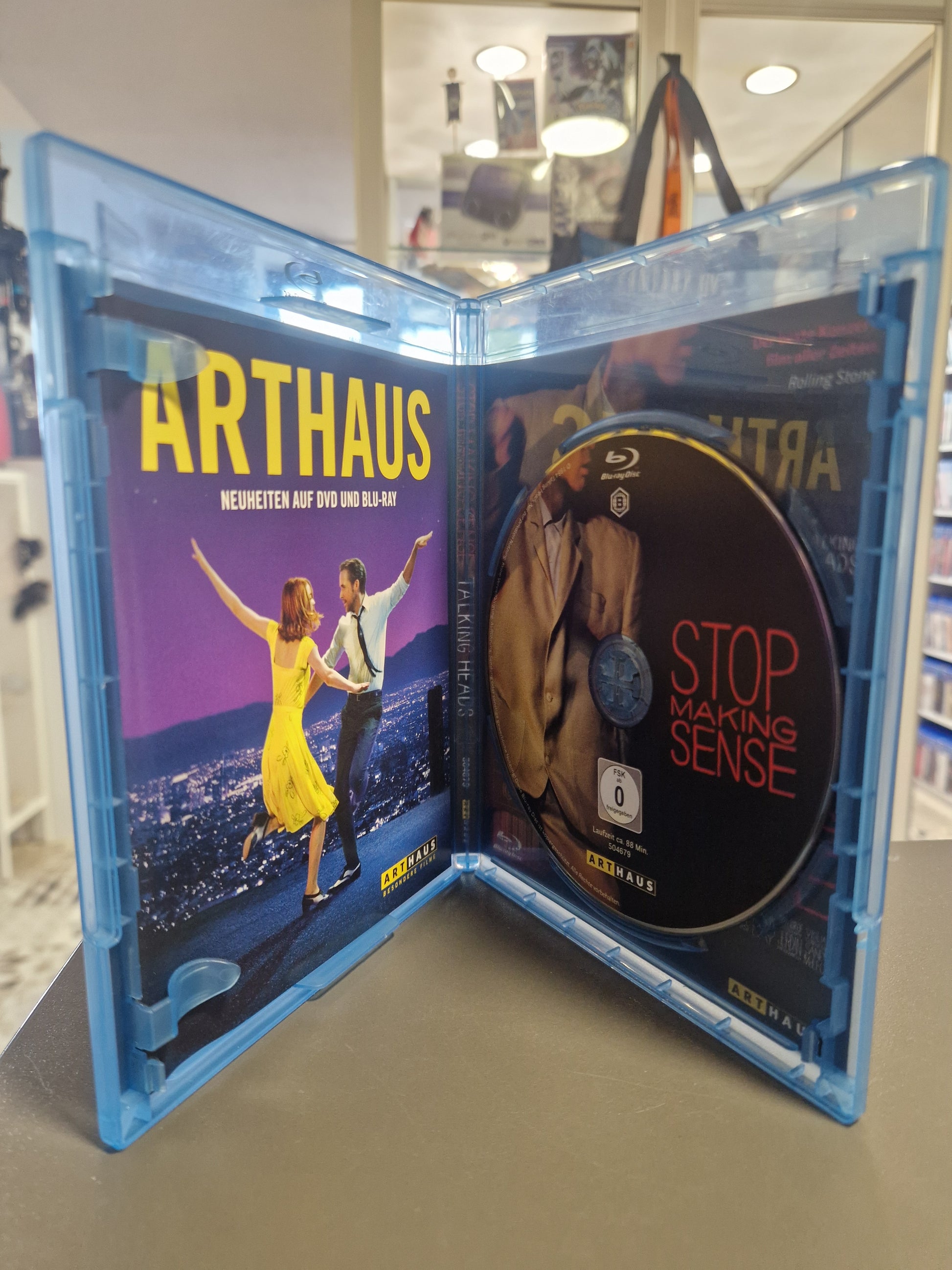 Geöffnete Blu-ray Hülle von Talking Heads Stop Making Sense mit der kratzerfreien Disc und dem Arthaus Werbeflyer.