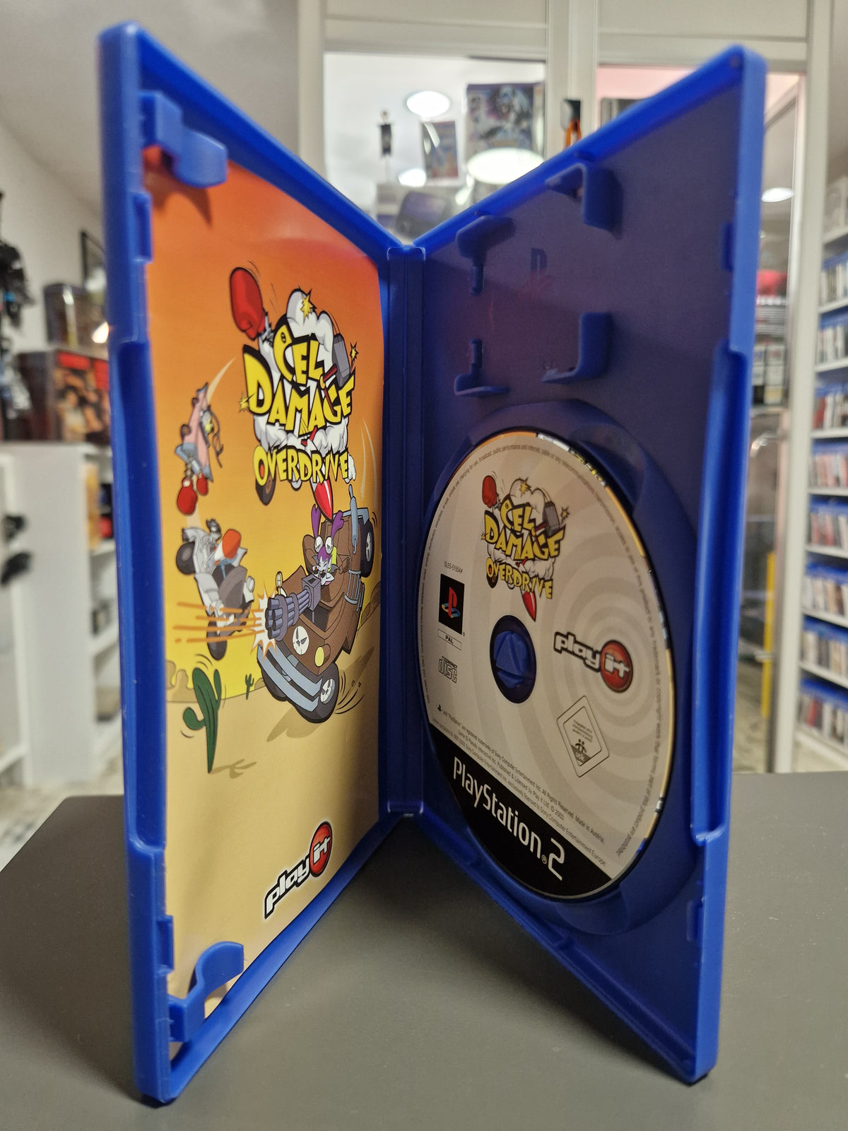 Geöffnete PlayStation 2 Hülle von Cel Damage Overdrive mit CD-ROM und Anleitung.