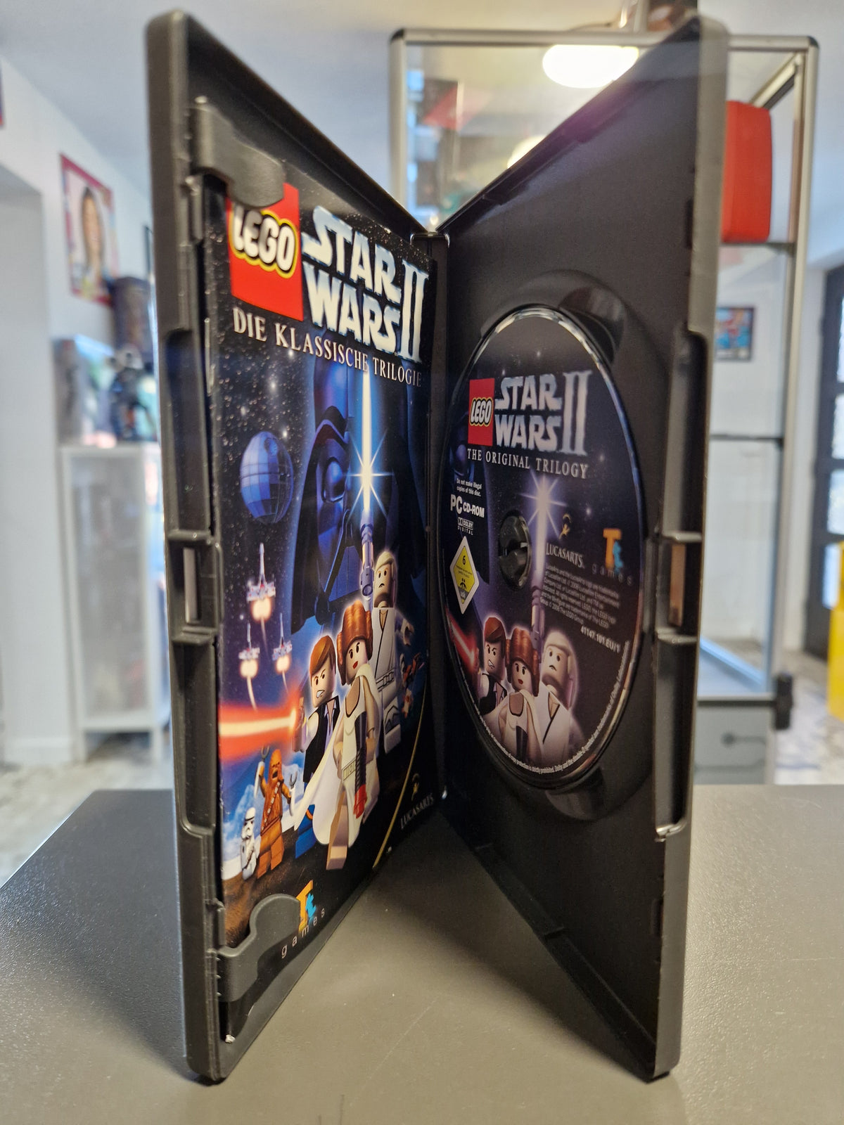 Geöffnete PC Hülle von LEGO Star Wars II mit CD-ROM und Handbuch.