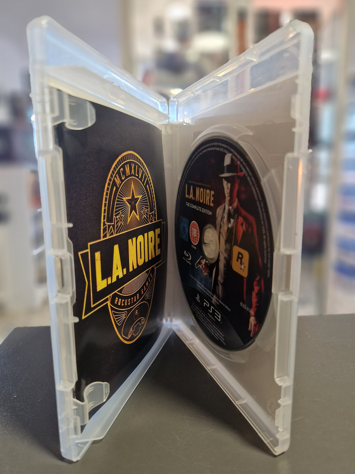 Geöffnete PS3 Hülle von L.A. Noire The Complete Edition mit Disc und Handbuch.