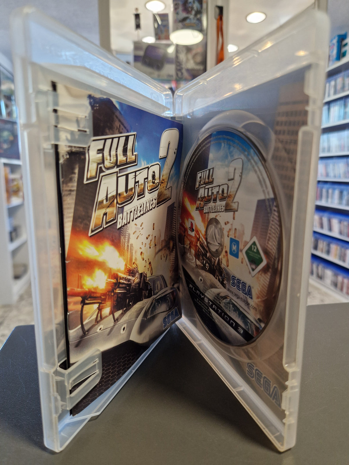 Geöffnete PlayStation 3 Hülle von Full Auto 2 Battlelines mit kratzerfreier Disc und Spielanleitung.
