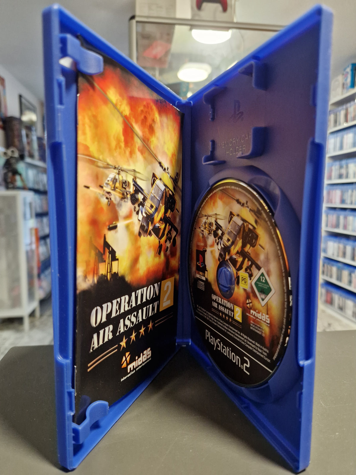 Geöffnete PS2 Hülle von Operation Air Assault 2 mit CD und Anleitungsheft.