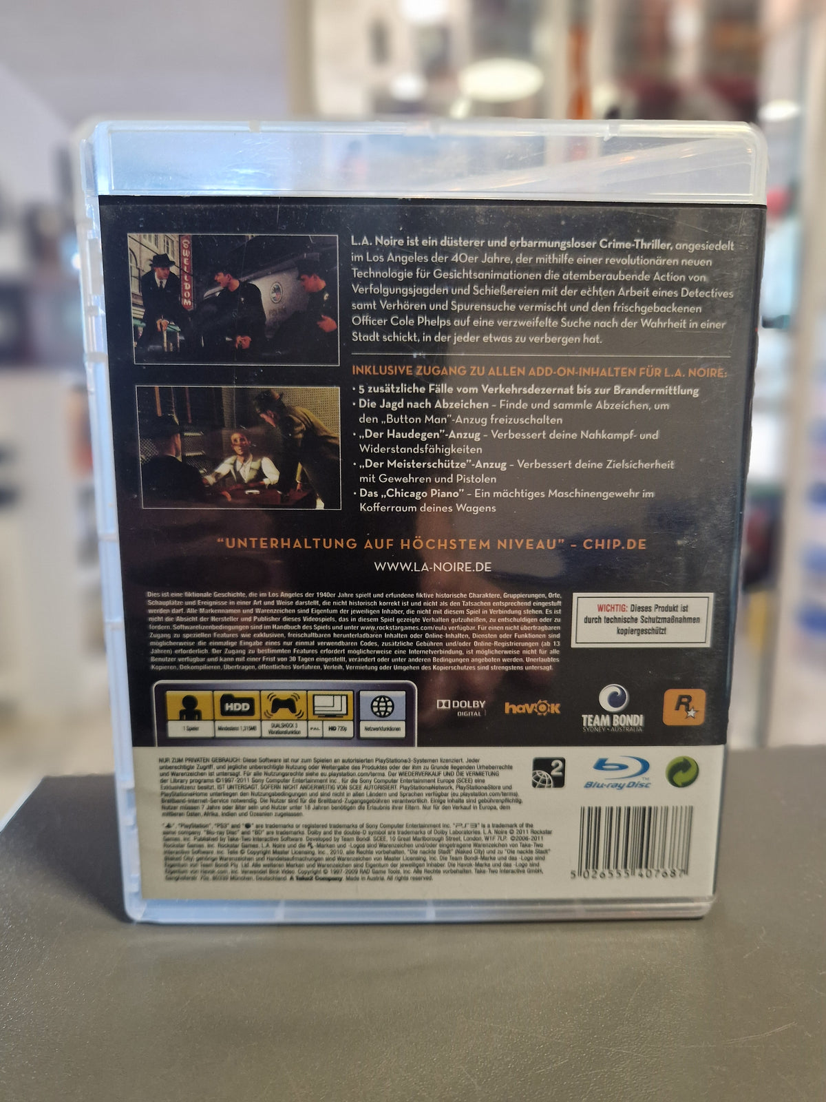 Rückseite der PS3 Hülle von L.A. Noire The Complete Edition mit Auflistung der Zusatzinhalte und Barcode 5026555407687.