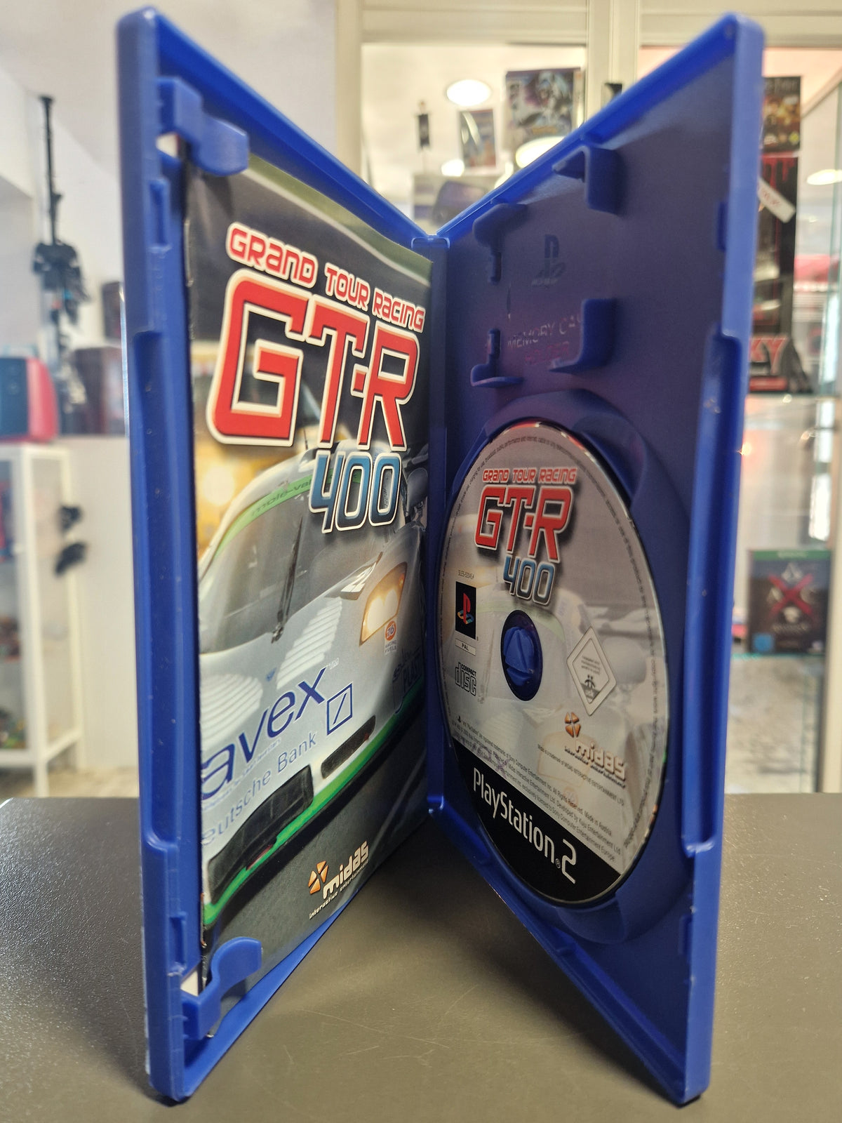 Geöffnete PS2 Spielehülle von Grand Tour Racing GTR-400 mit Disc und Anleitungsheft.