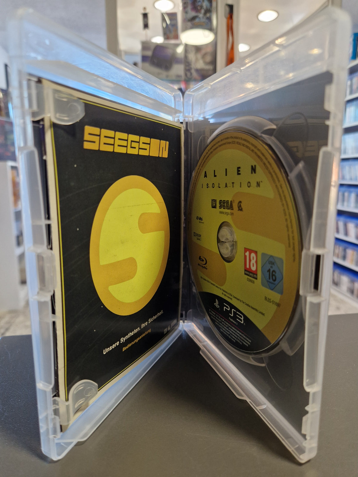 Geöffnete PlayStation 3 Hülle von Alien Isolation mit kratzerfreier Disc und Seegson Bedienungsanleitung.
