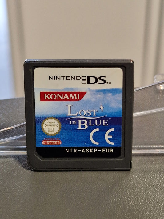 Nintendo DS Modul von Lost in Blue (NTR-ASKP-EUR) mit dem blauen Konami-Cover auf einem Acryl-Spieleaufsteller bei Memory Lane Rhauderfehn.