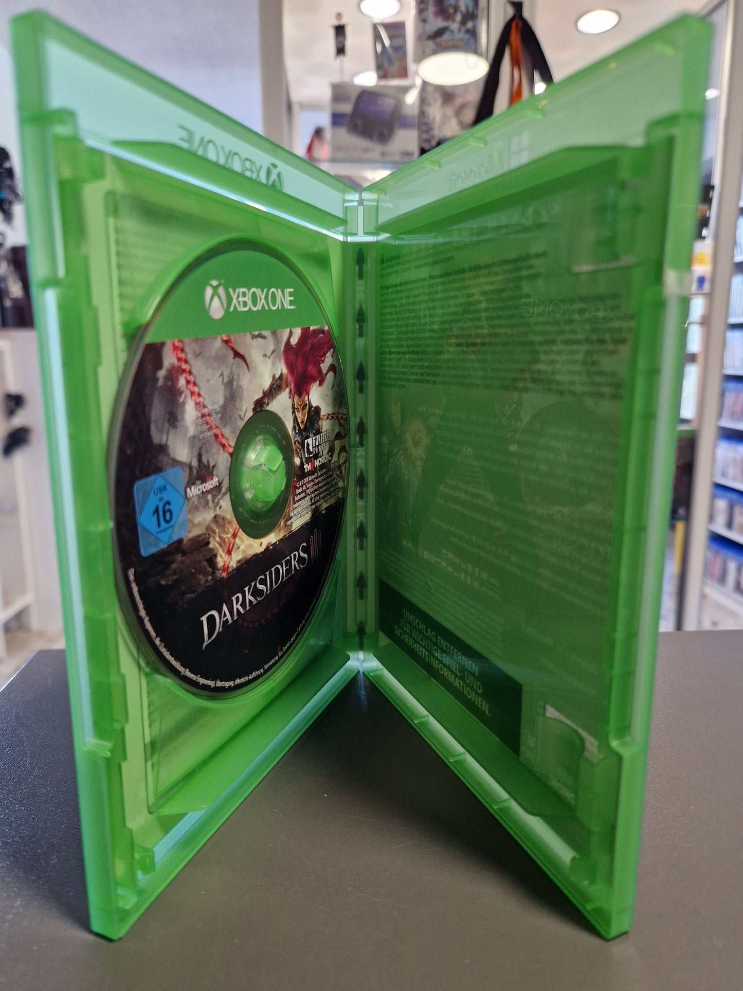 Geöffnete Xbox One Hülle von Darksiders 3 mit der sauberen, kratzerfreien Spiel-Disc auf der linken Seite.