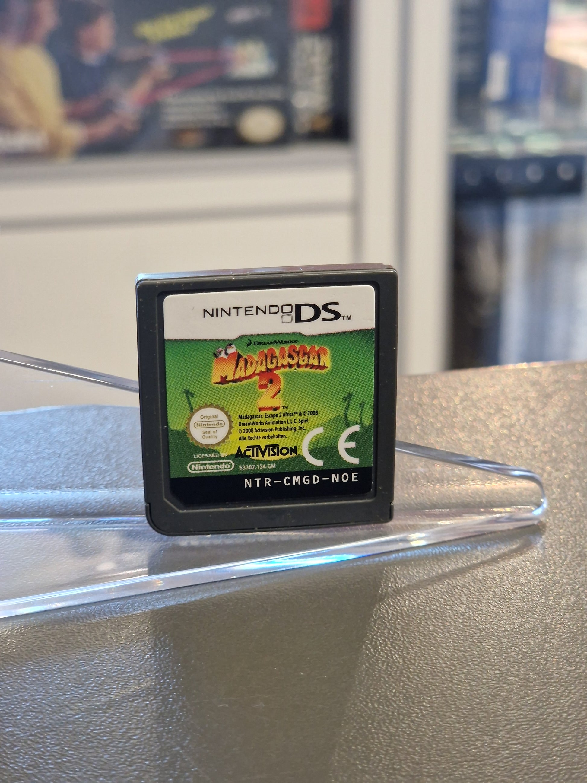 Nahaufnahme des Nintendo DS Moduls „Madagascar 2“ mit dem grünen Label und den Filmcharakteren.