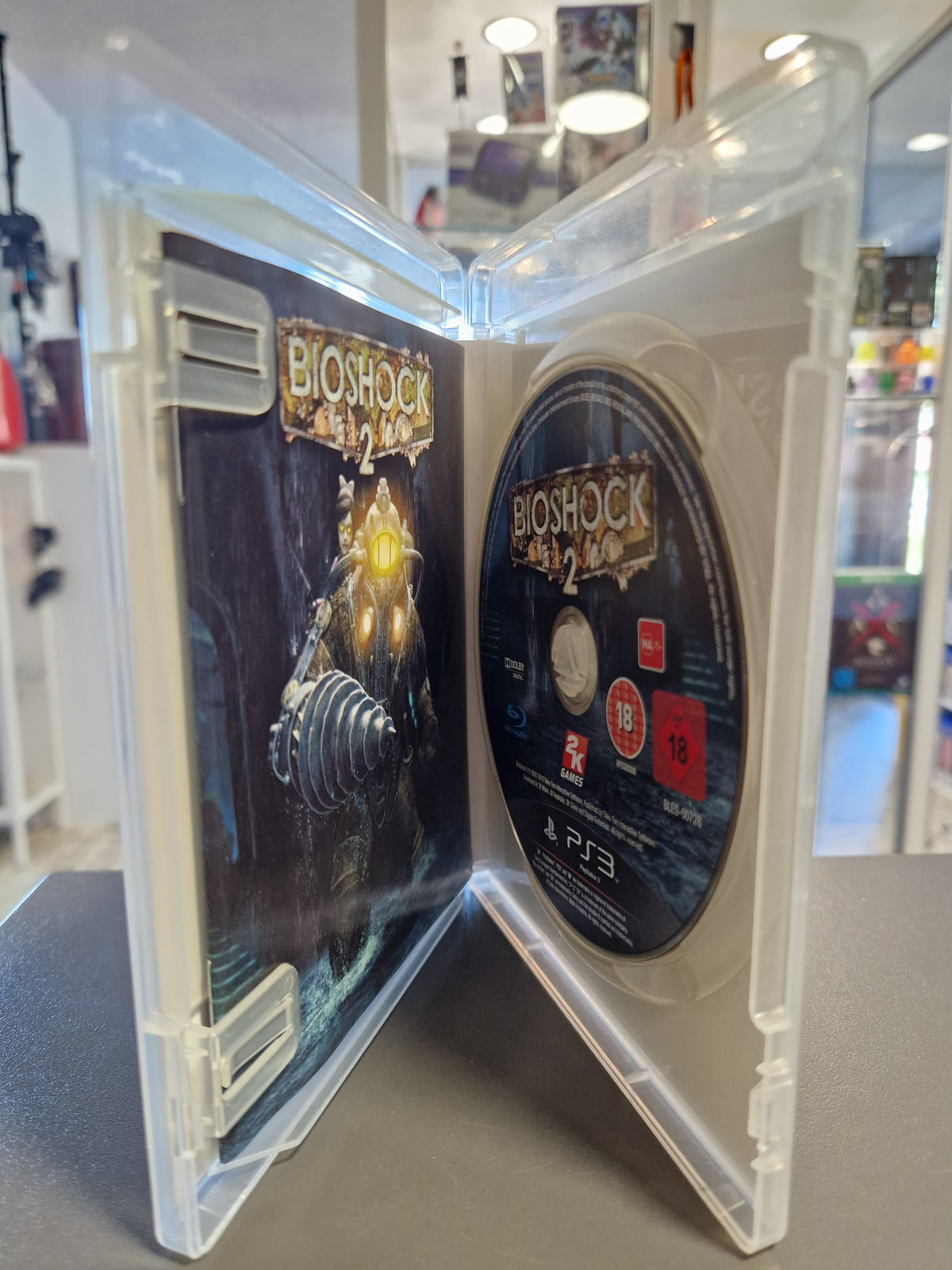 Geöffnete PlayStation 3 Hülle von BioShock 2 mit kratzerfreier Disc und Spielanleitung.