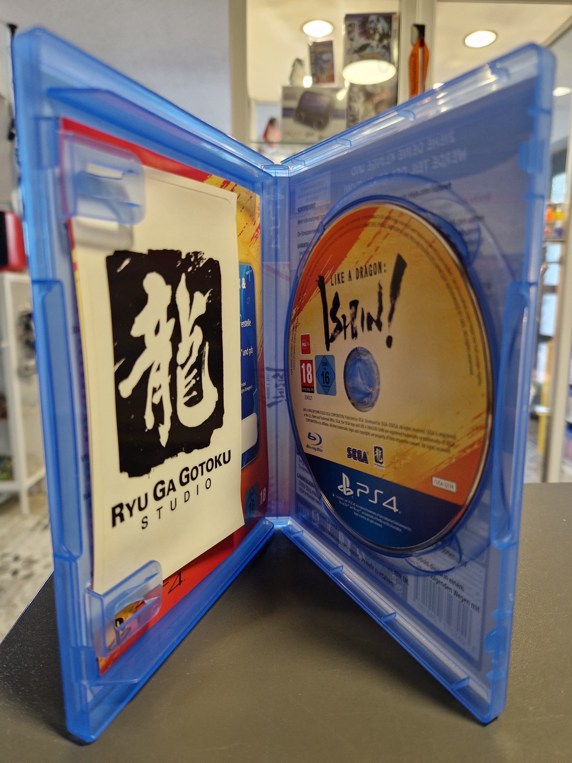Geöffnete PS4 Hülle mit kratzerfreier Blu-ray und den Ryu Ga Gotoku Studio Aufklebern.