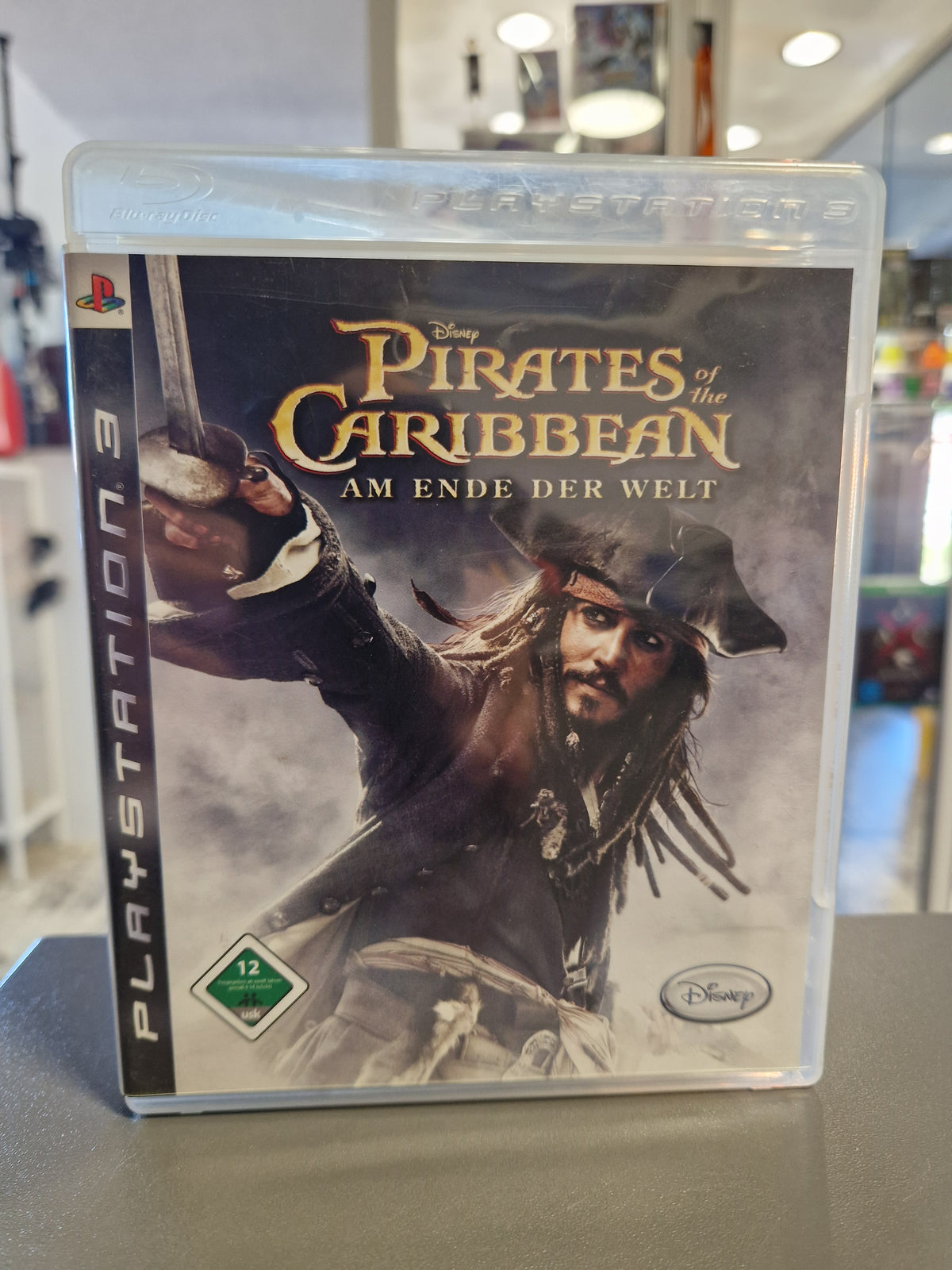 Vorderseite der PlayStation 3 Hülle von Pirates of the Caribbean Am Ende der Welt mit Captain Jack Sparrow und USK 12 Logo.