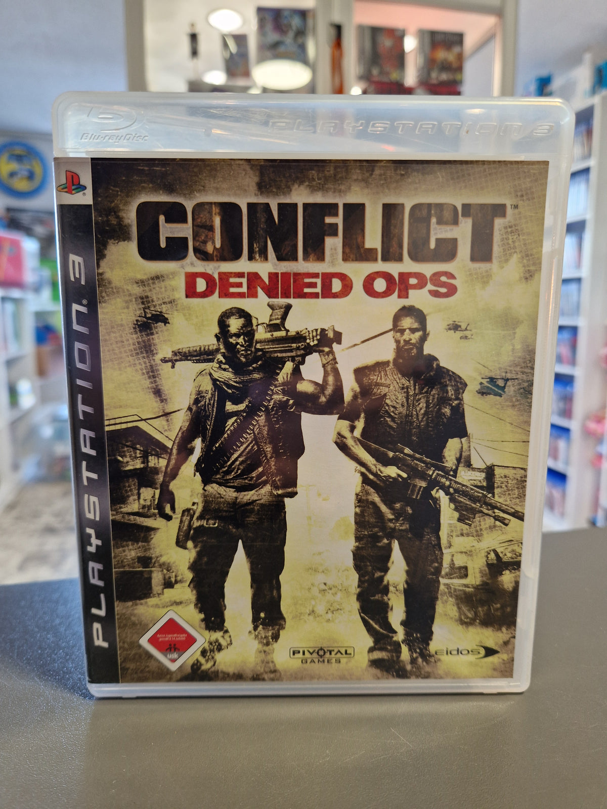 Vorderseite der Hülle von Conflict Denied Ops für PlayStation 3 mit USK 18 Logo.