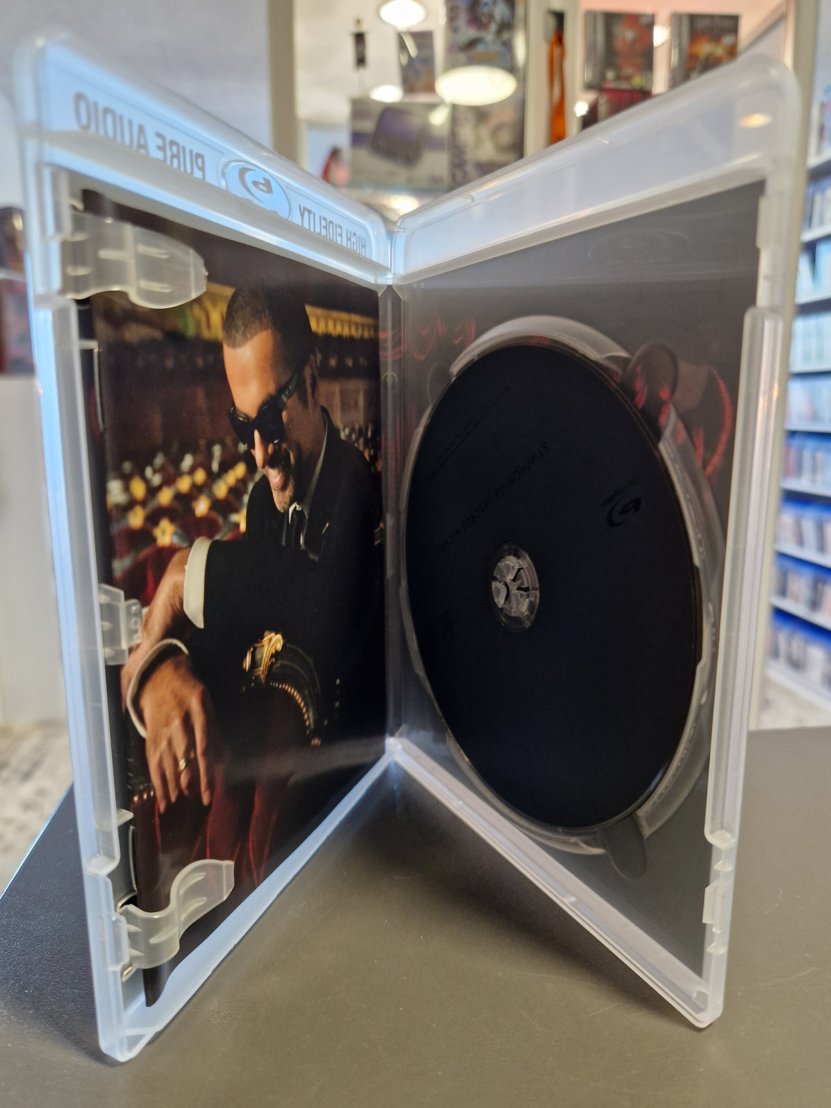 Geöffnete weiße Pure Audio Blu-ray Hülle von George Michael Symphonica mit schwarzer Disc.
