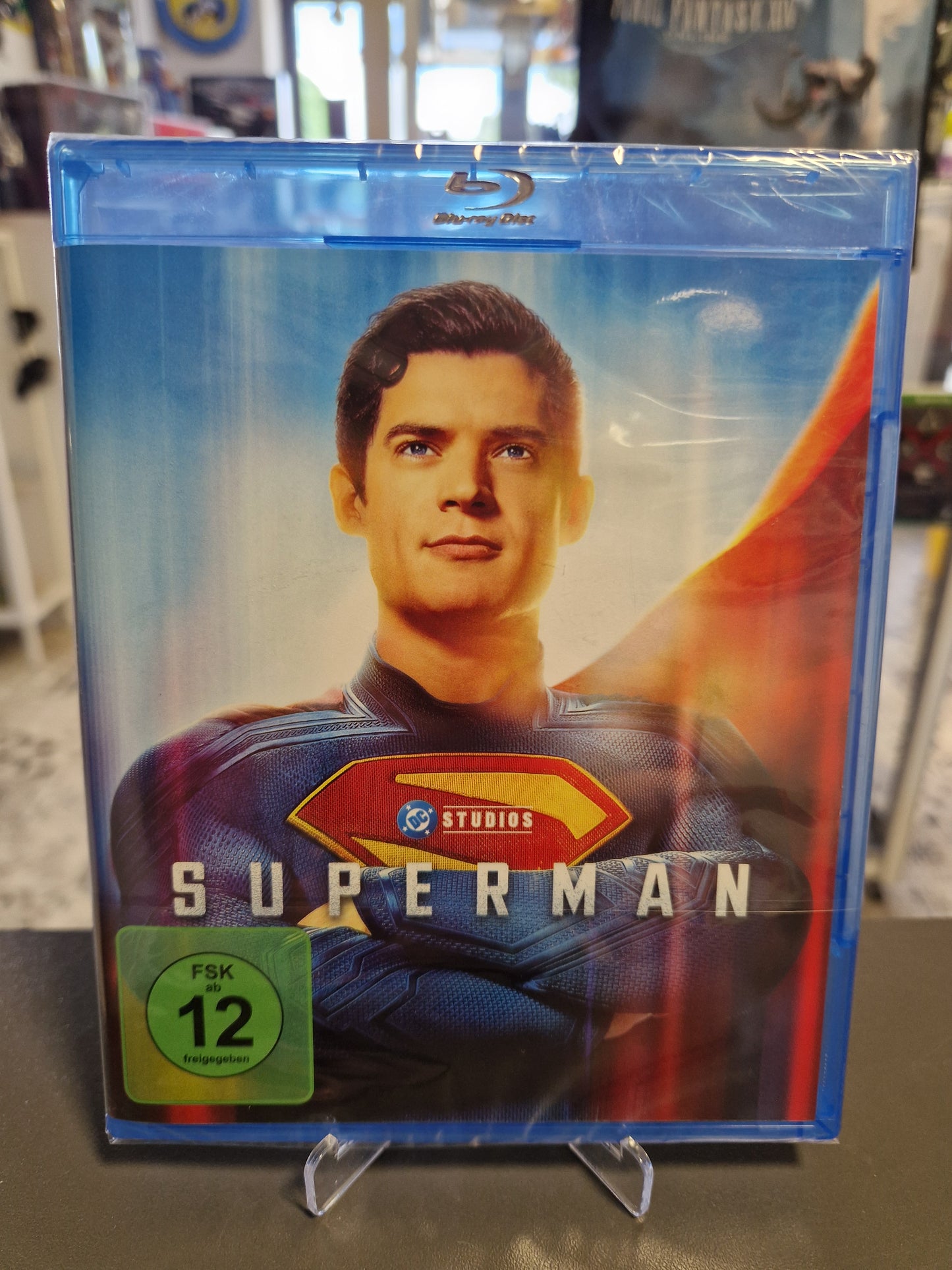 Vorderseite der originalverpackten Blu-ray Hülle von Superman (Regie James Gunn) mit David Corenswet im blauen Superheldenanzug mit DC Studios Logo und grünem FSK 12 Emblem.