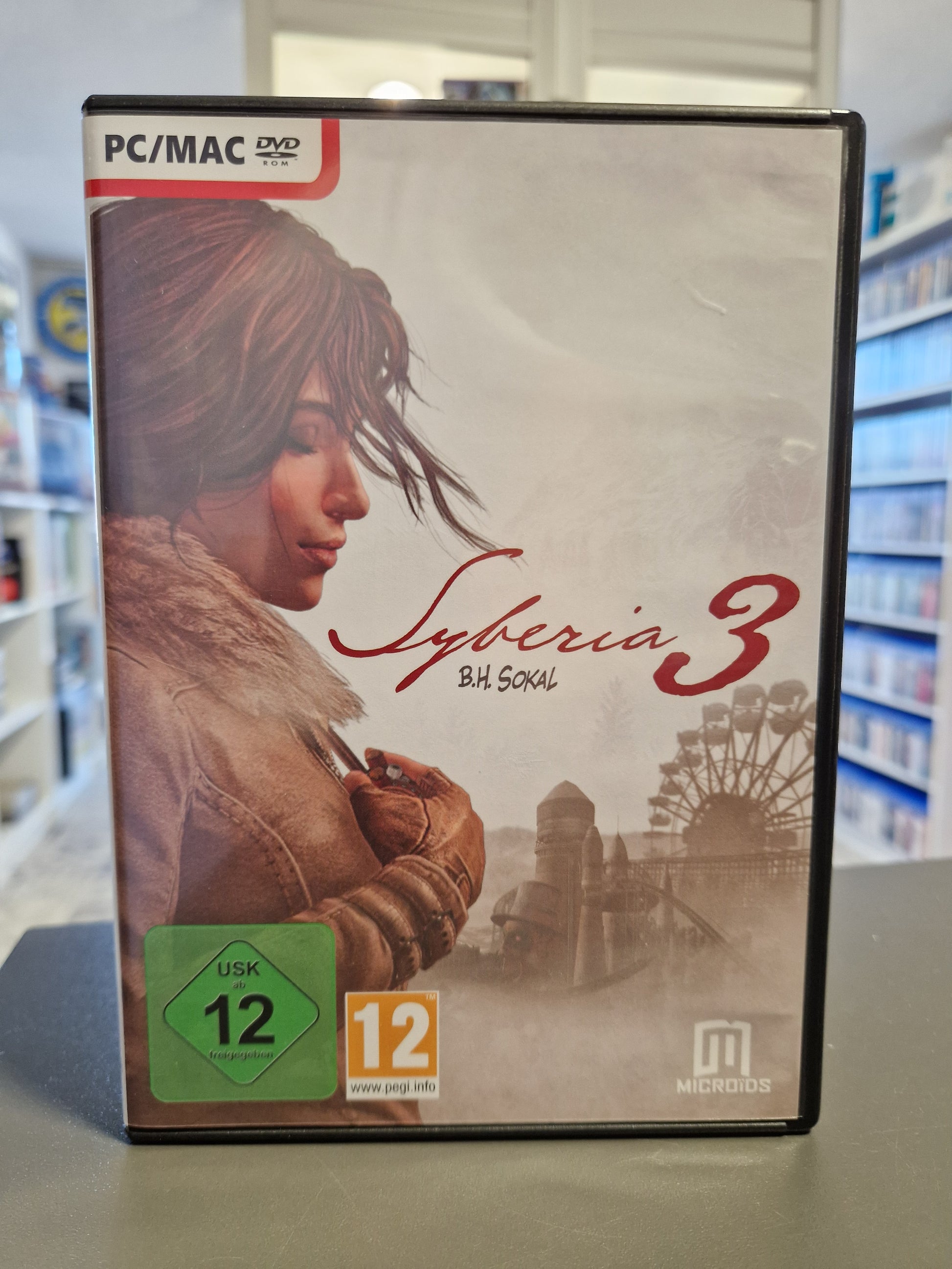 Syberia 3 PC Spiel Hülle mit Kate Walker vor mechanischen Kulissen.